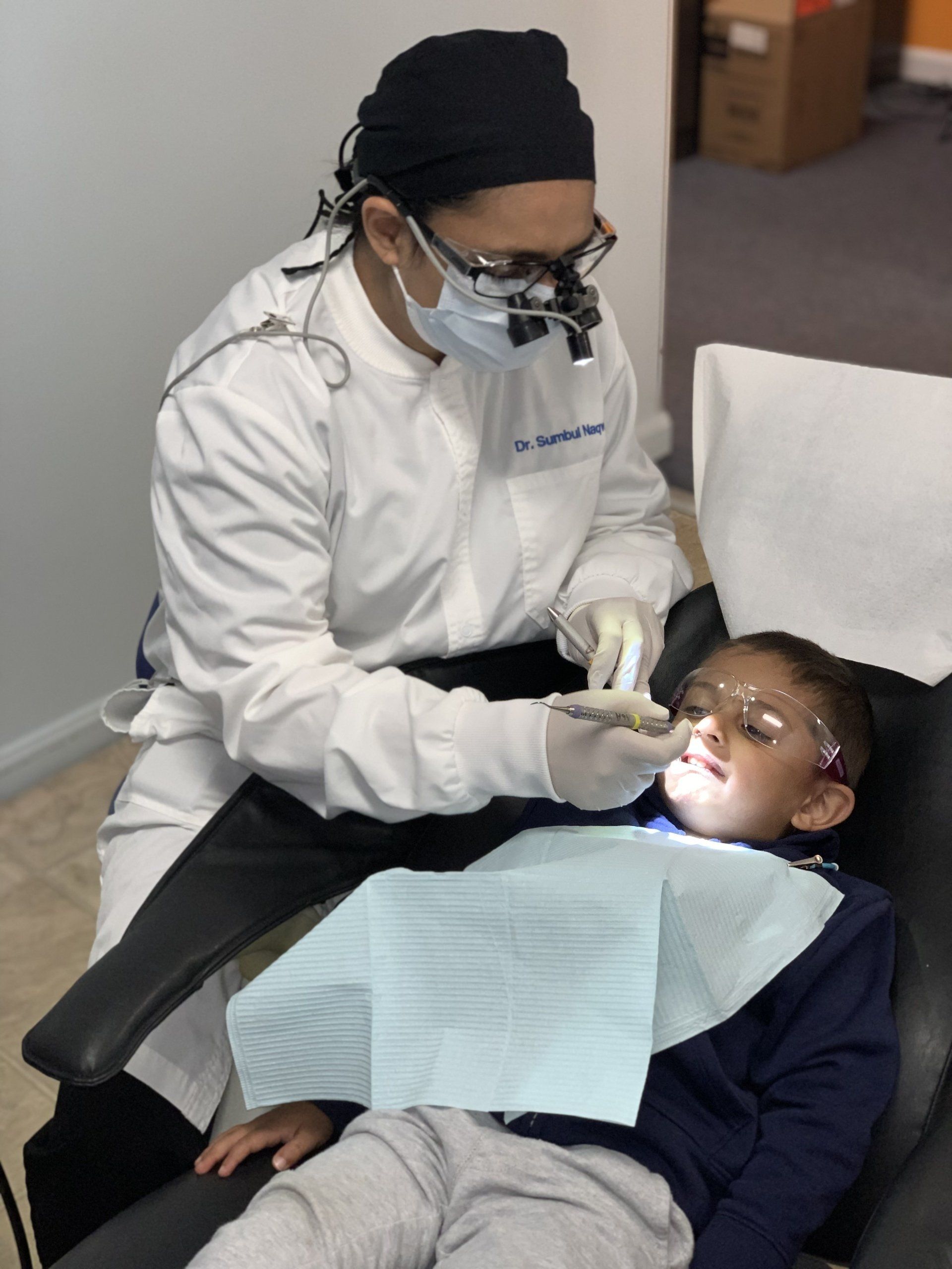 dentist checking a african little boy's teeth