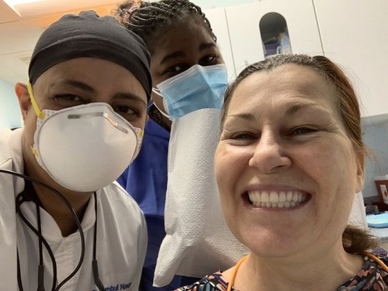 old female patient smiling with 2 dentist