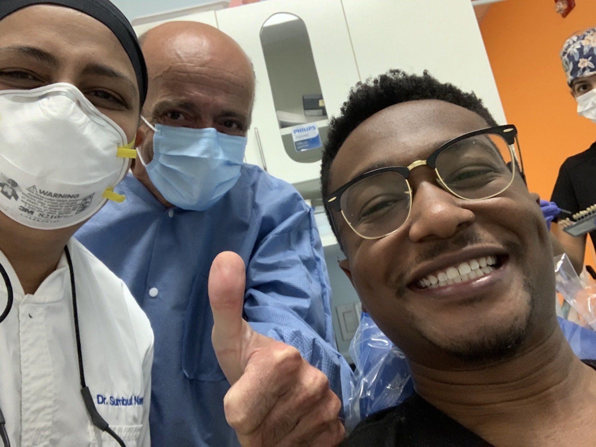male african patient smiling with 2 dentists