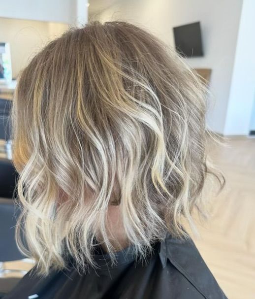 Blonde bob with wavy layers, soft highlights.