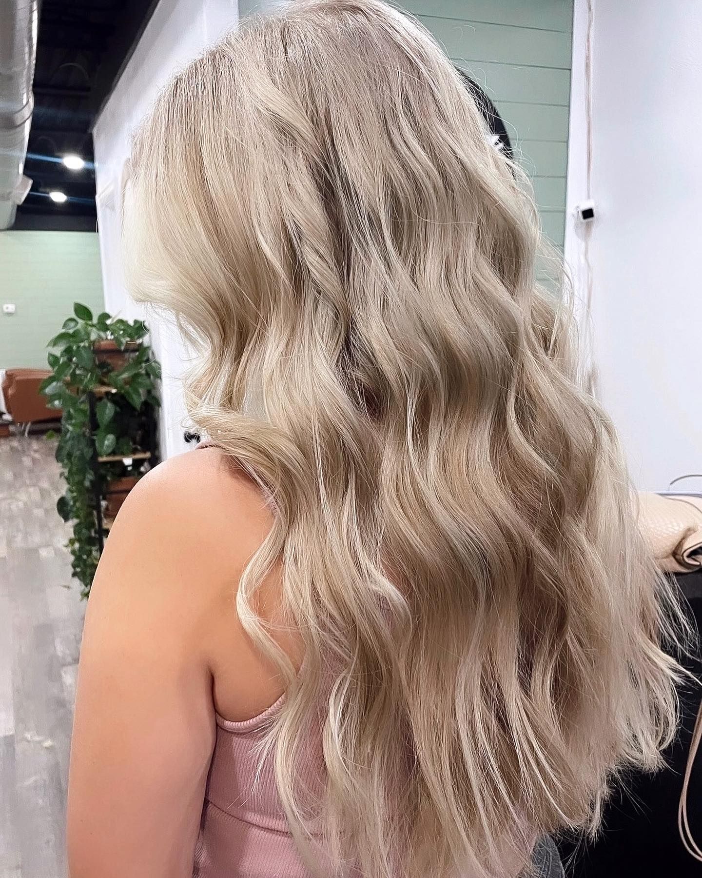 Long, wavy blonde hair; salon setting.