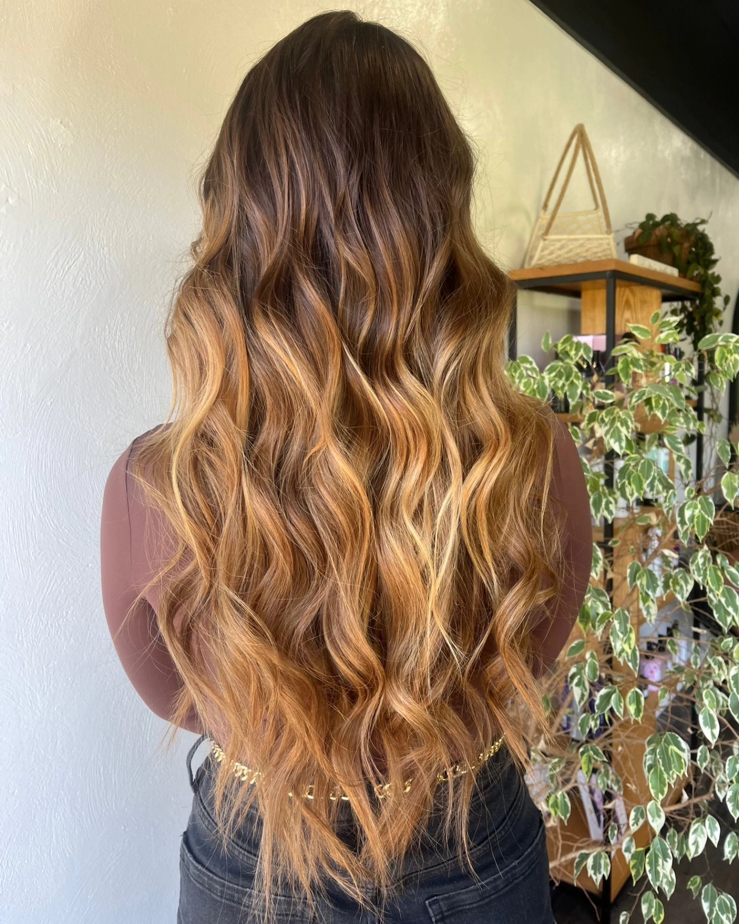 Woman with long wavy hair in shades of brown and blonde.