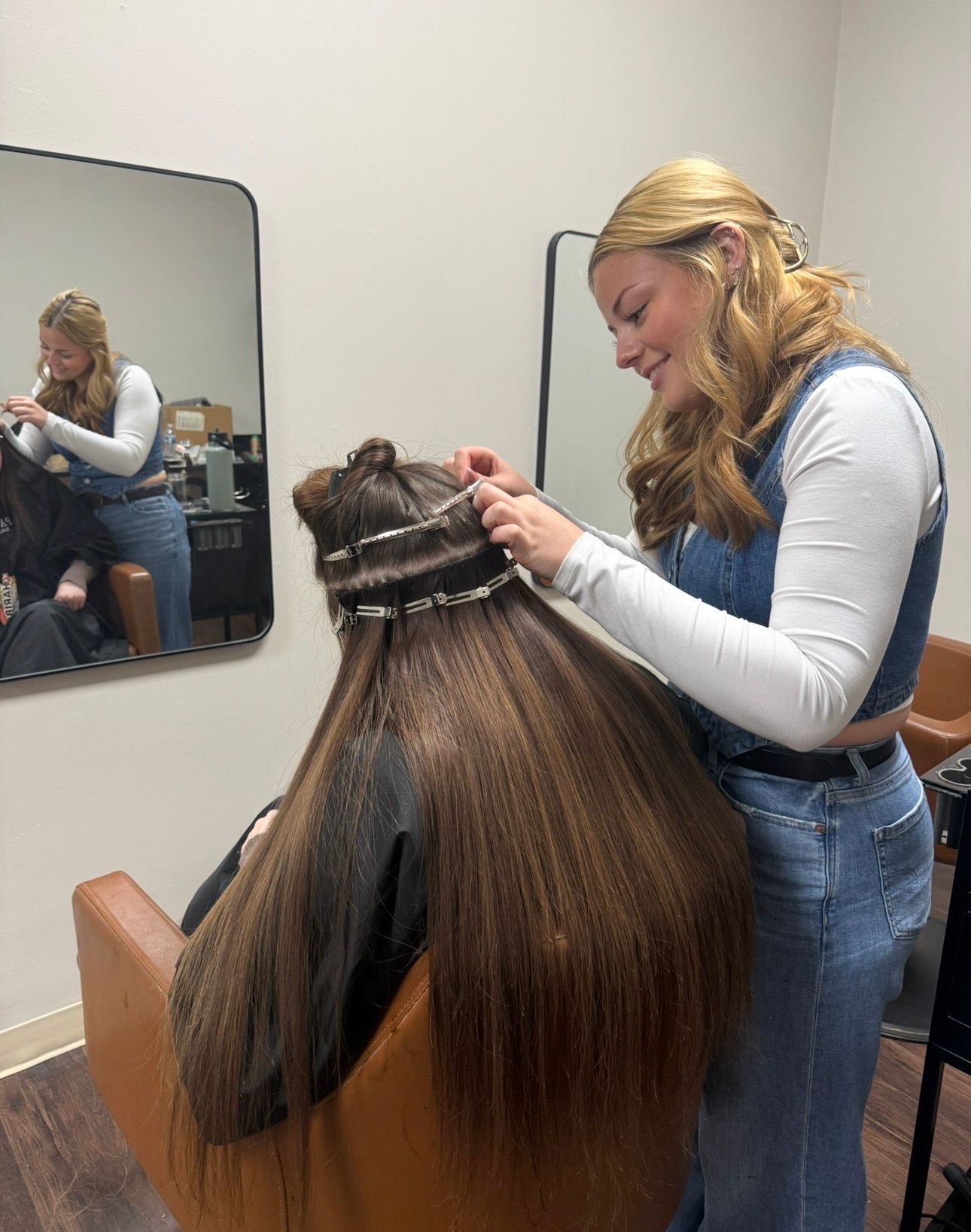 Hands getting a manicure with pink gloves, tools, and a white pillow.