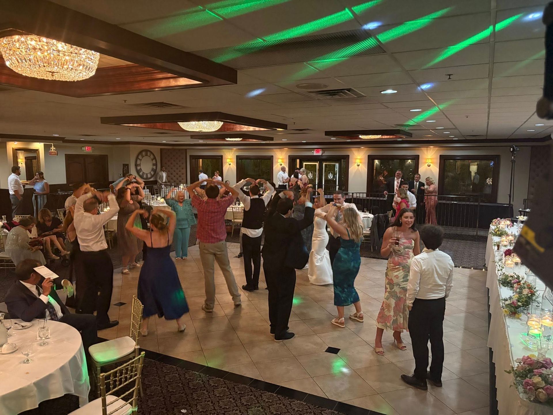Couple dancing at a wedding reception, dipped in front of smoky stage lights.