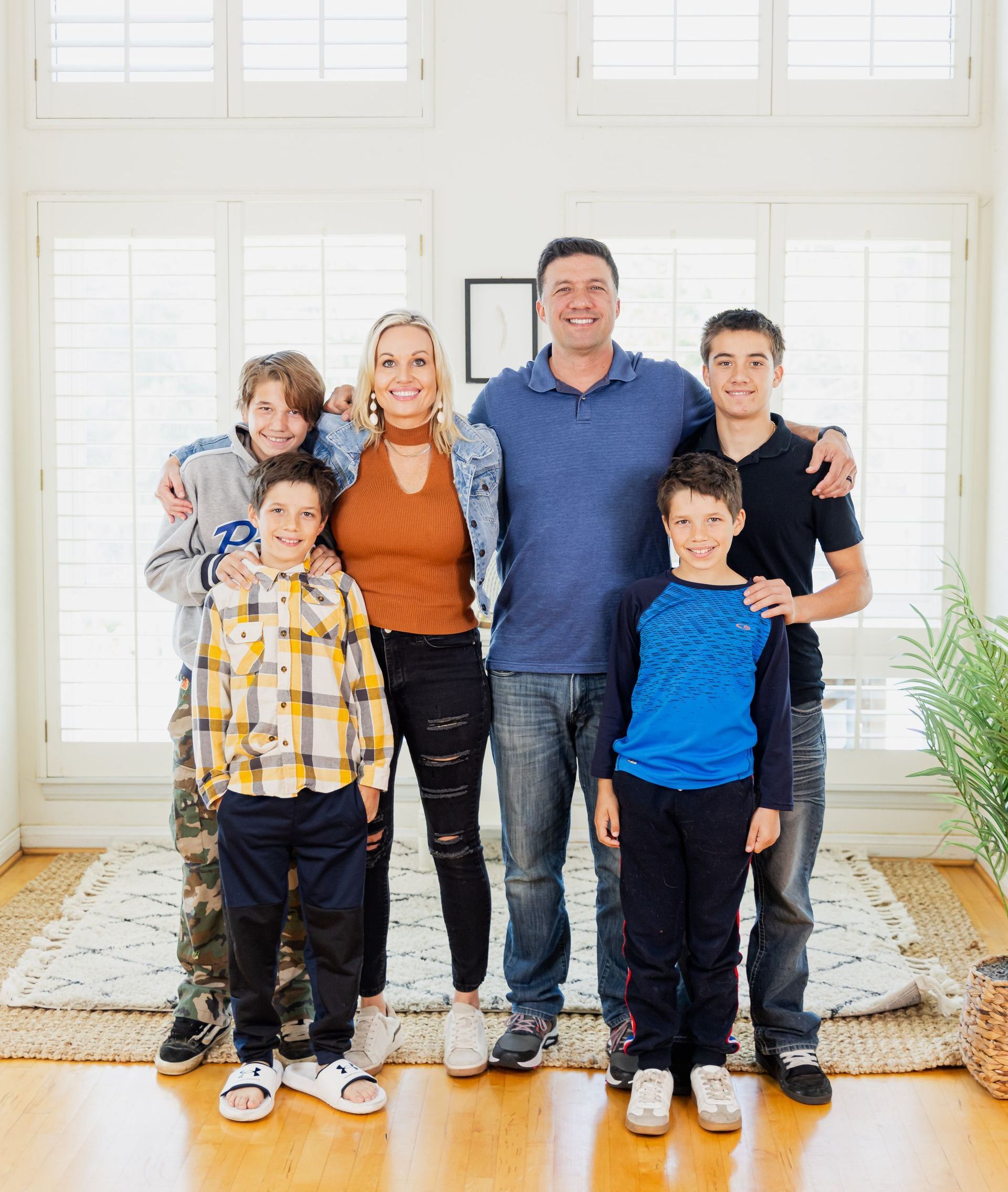 A family is posing for a picture in a living room.