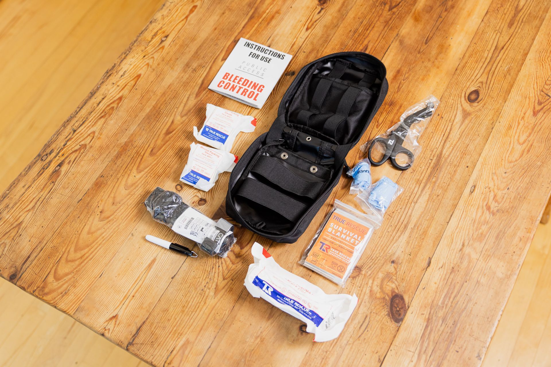 A first aid kit is sitting on a wooden table.