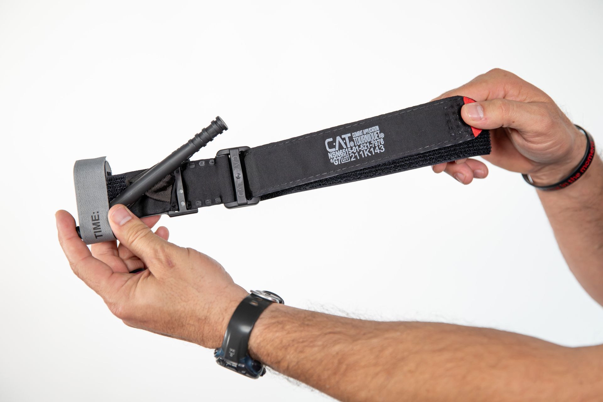 A person is holding a tactical tourniquet in their hands.