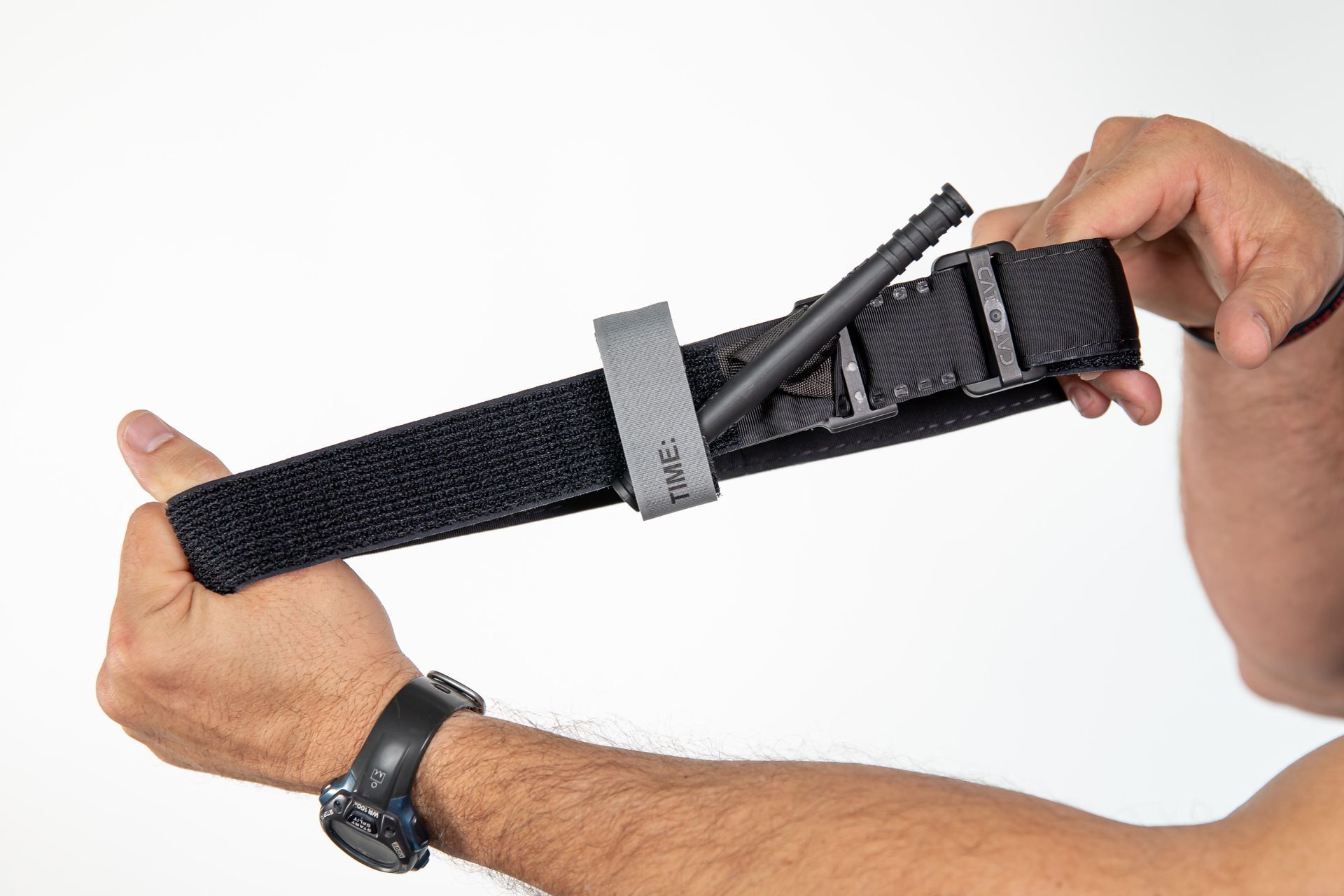 A person is holding a tactical tourniquet in their hands.