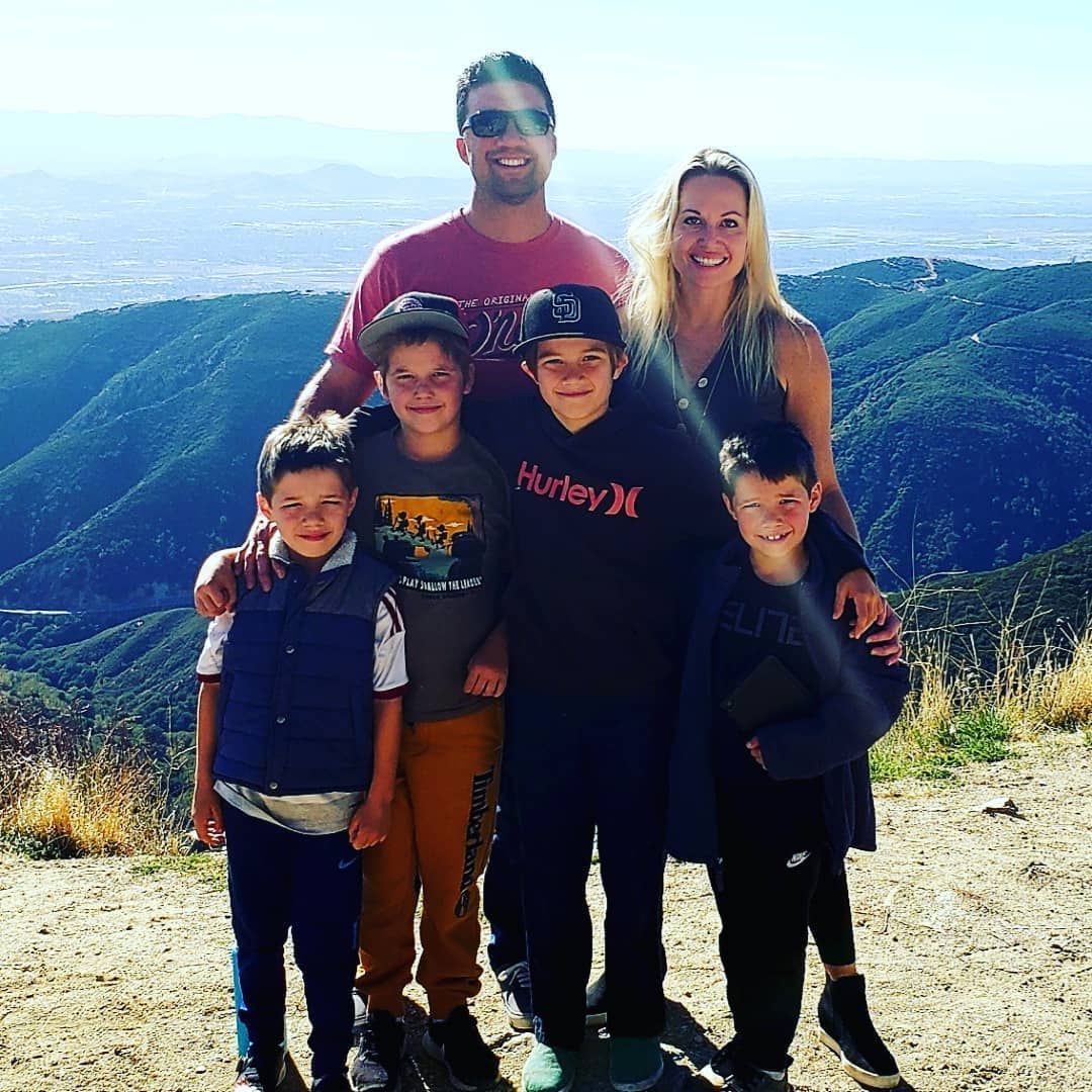 A family posing for a picture on top of a hill.