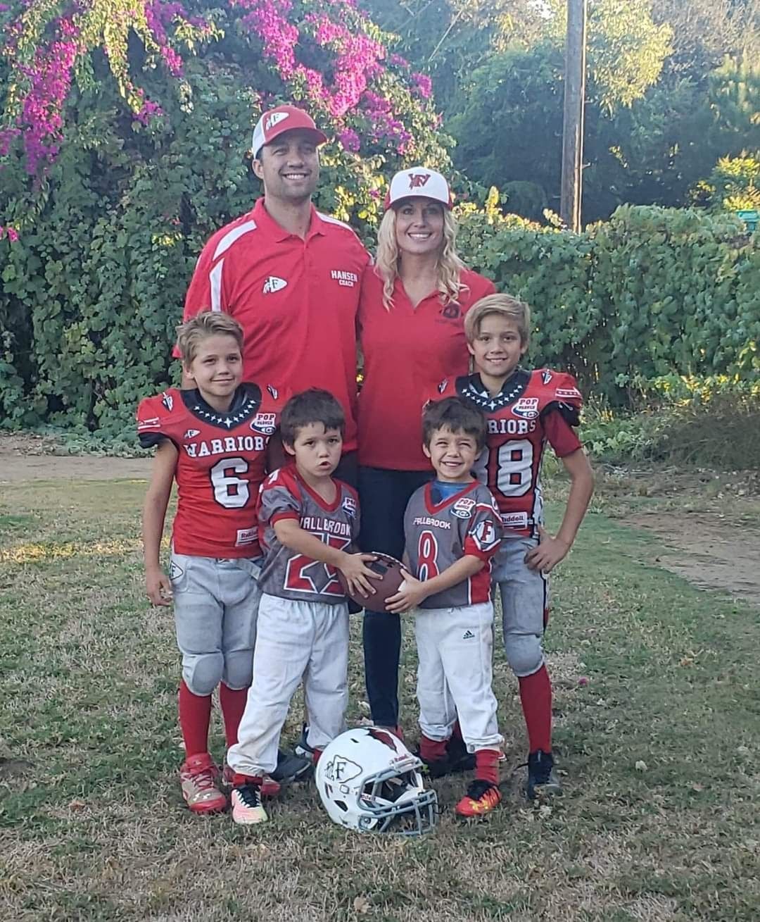 A family posing for a picture with a football and a helmet.