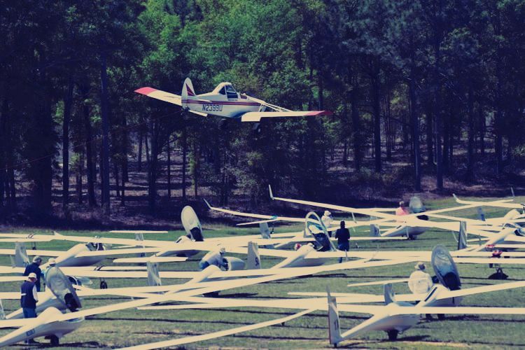 A plane is flying over a field of planes