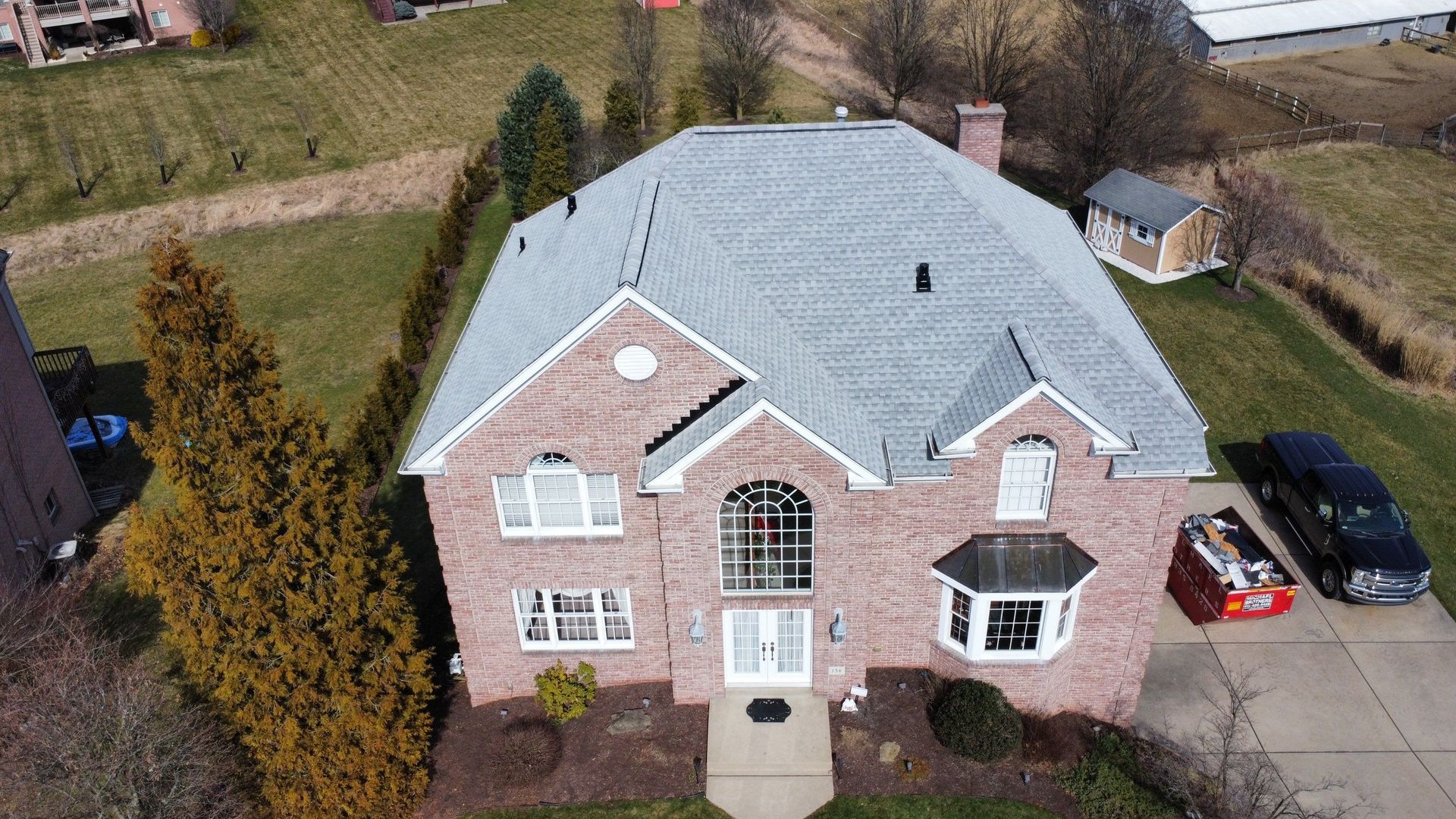 Team of roofers installing a new roof, emphasizing Pittsburgh replacement costs.