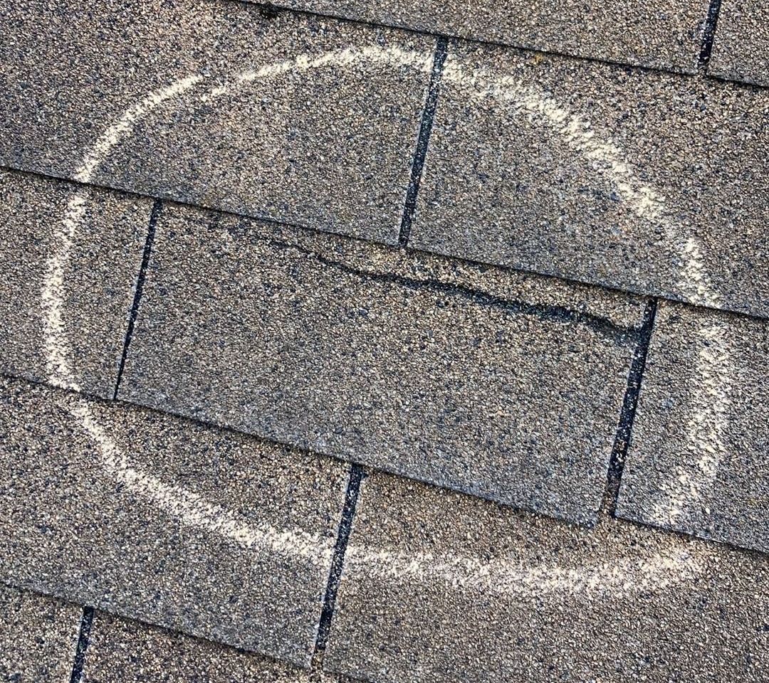 Cracked roof shingle from wind storm