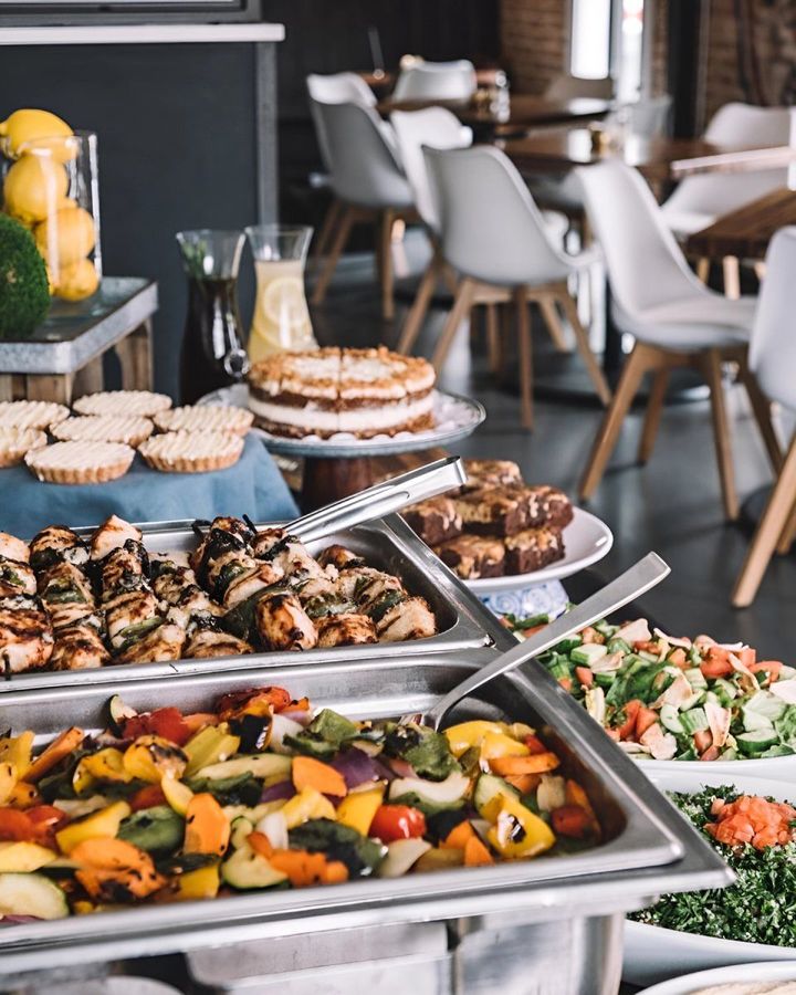 A buffet with a variety of food and desserts in a restaurant.