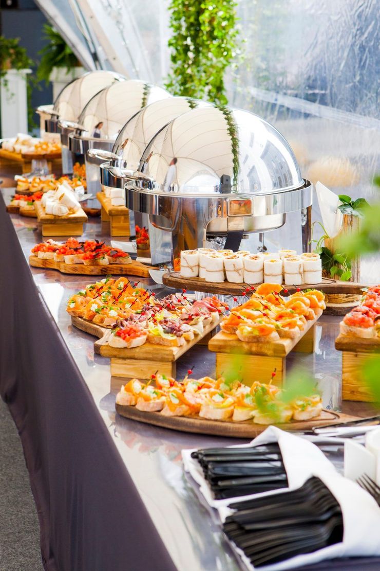 A buffet table filled with lots of food and utensils.