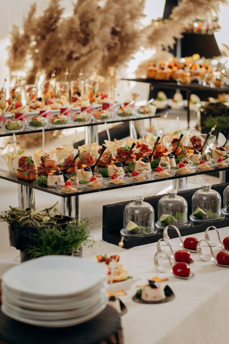 A buffet table filled with lots of food and plates.