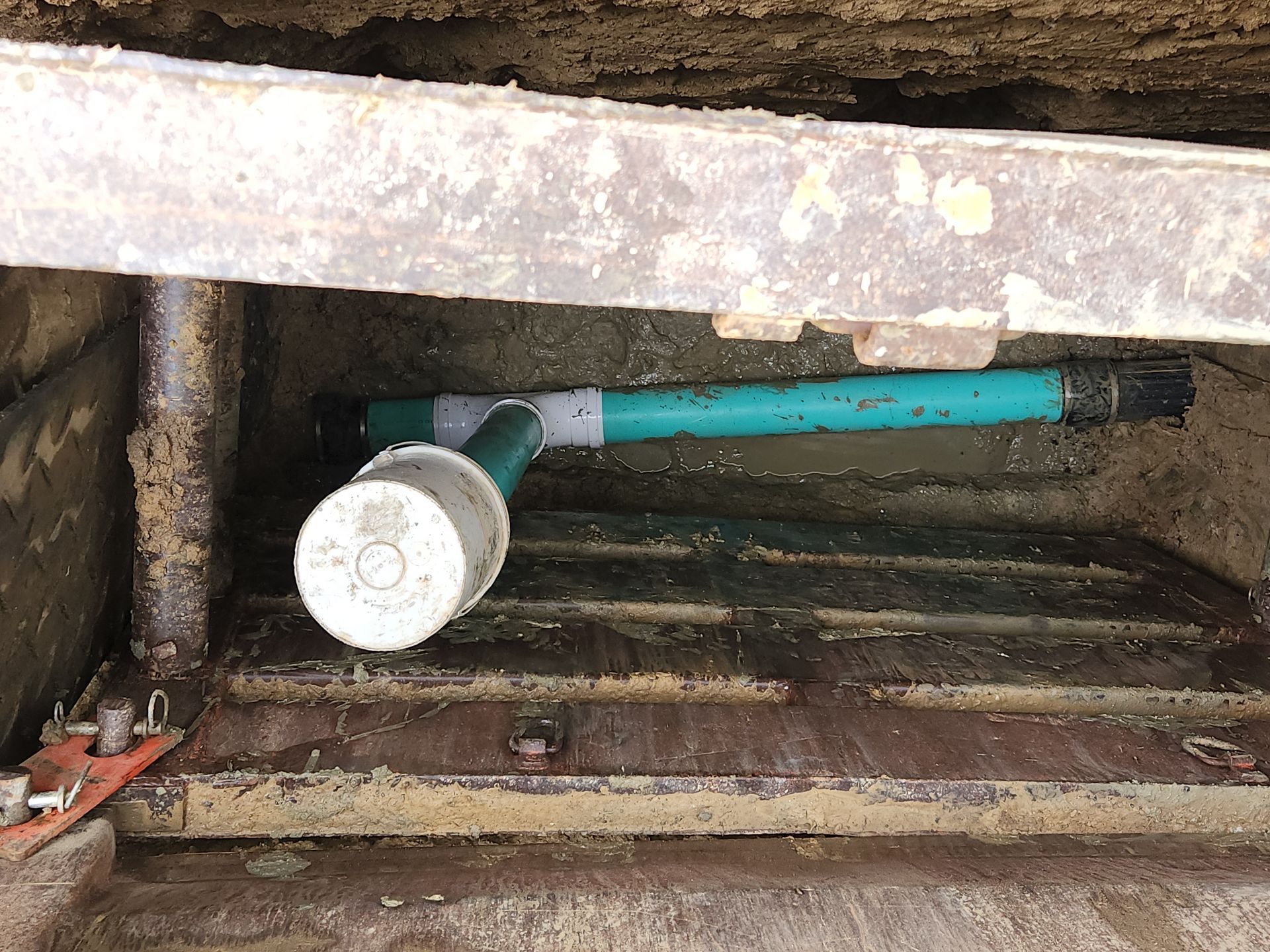 Worker emptying household septic tank and cleaning sludge from septic system.