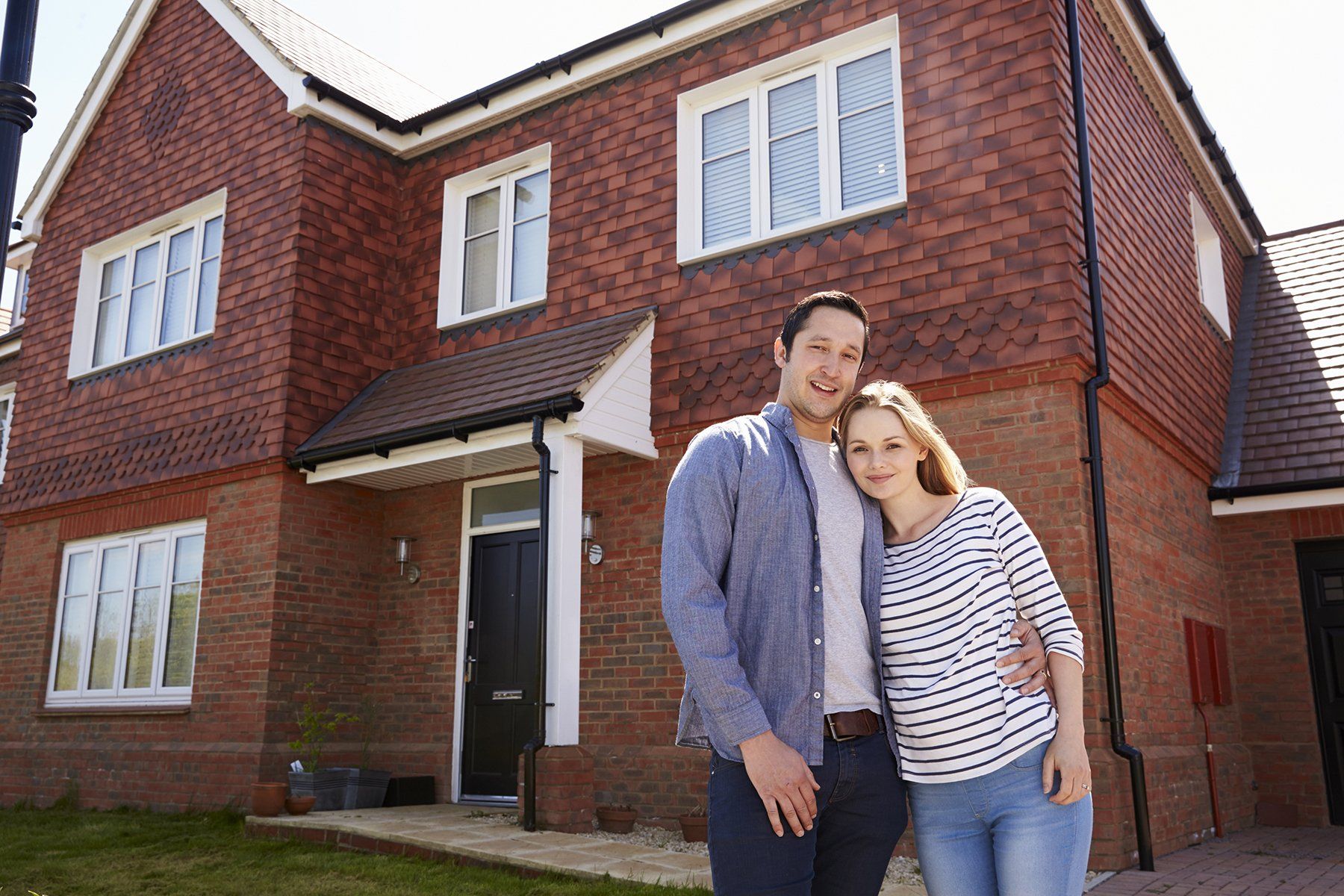 Couple standing outside their new home