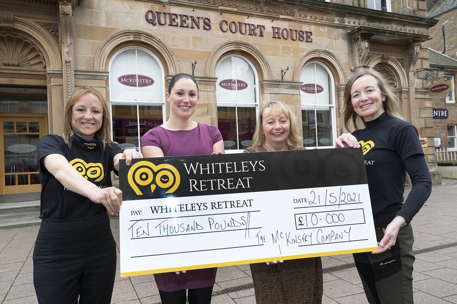 Whiteley's Retreat and McKinstry Company staff holding a large novelty cheque