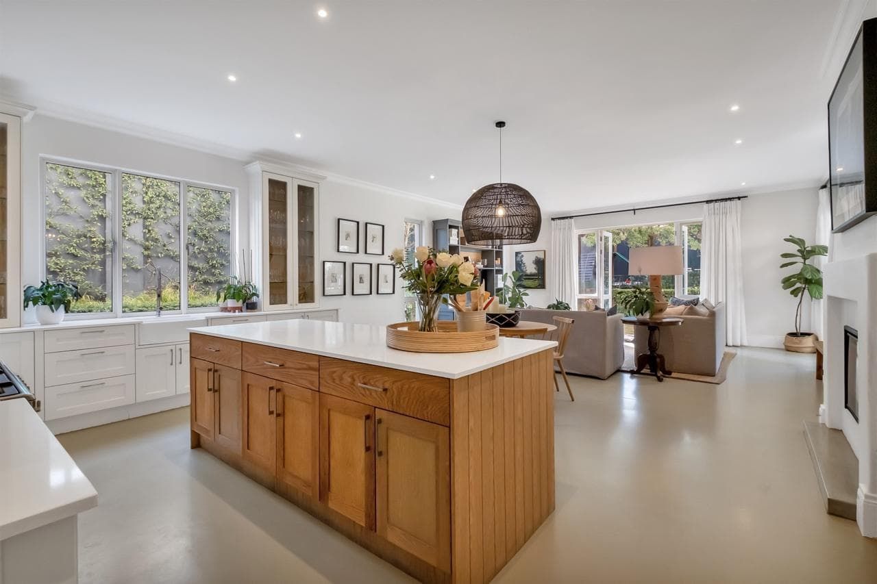 A large white house with a brick driveway leading to it