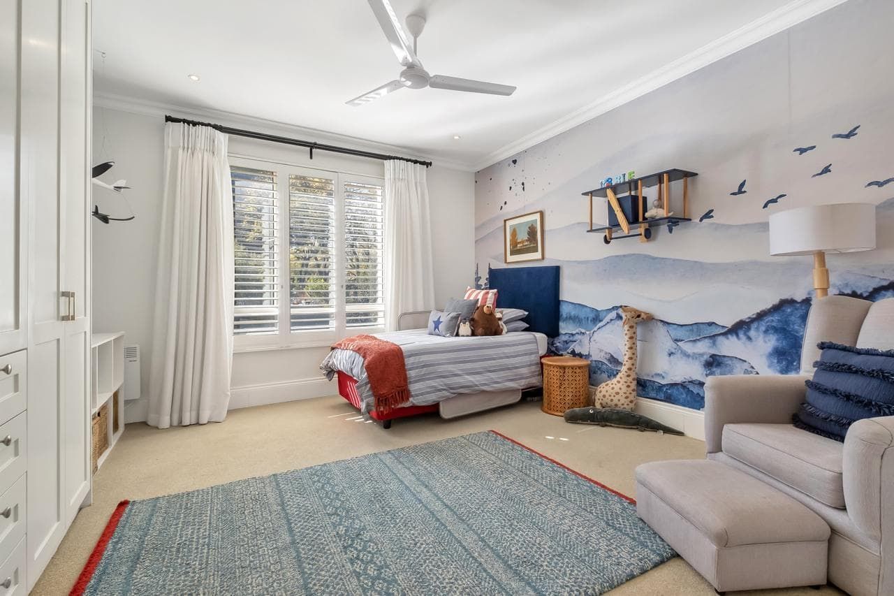 A kitchen with white cabinets , stainless steel appliances , and a large island.