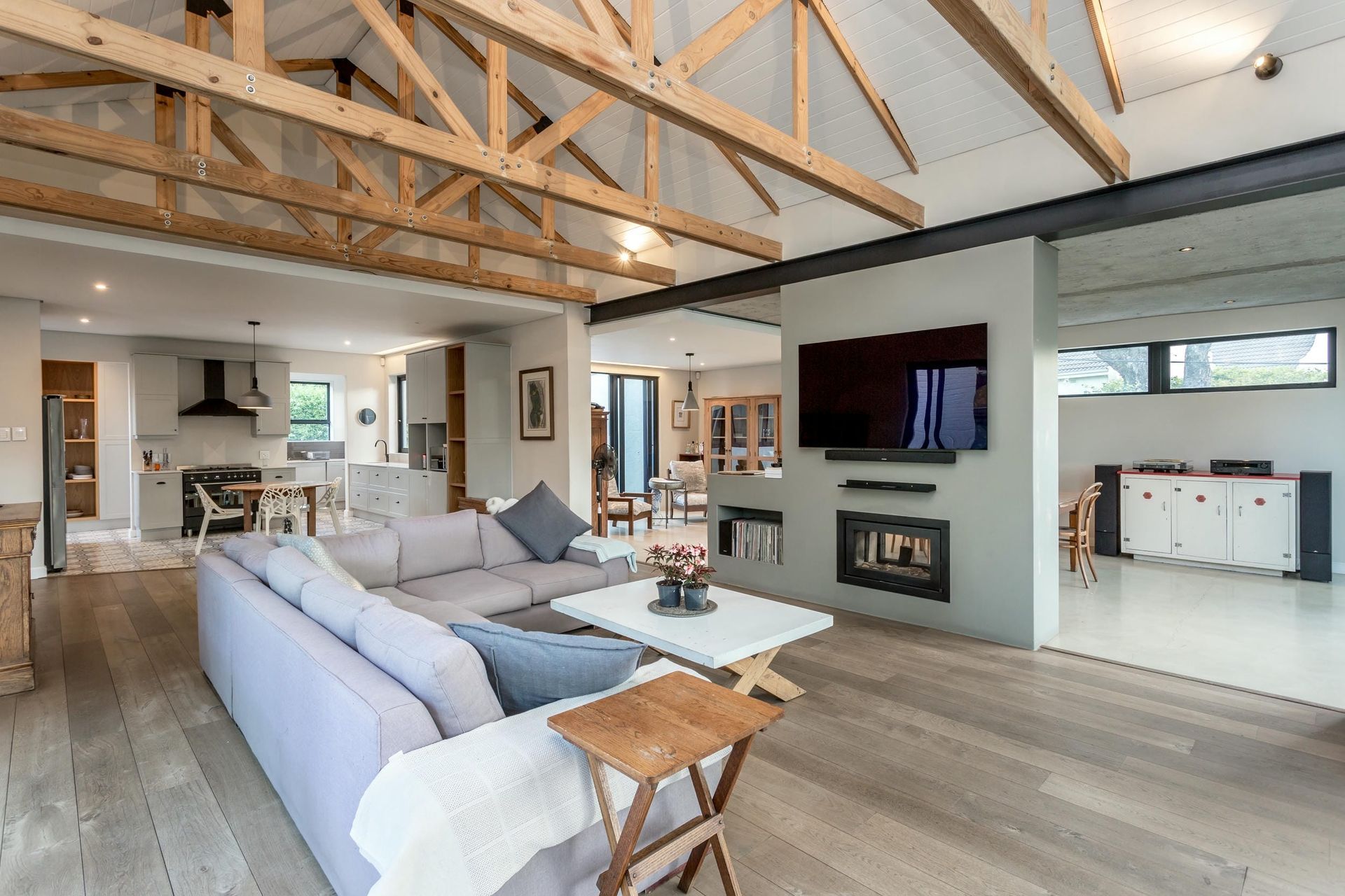 A living room with a couch , table , television and fireplace.