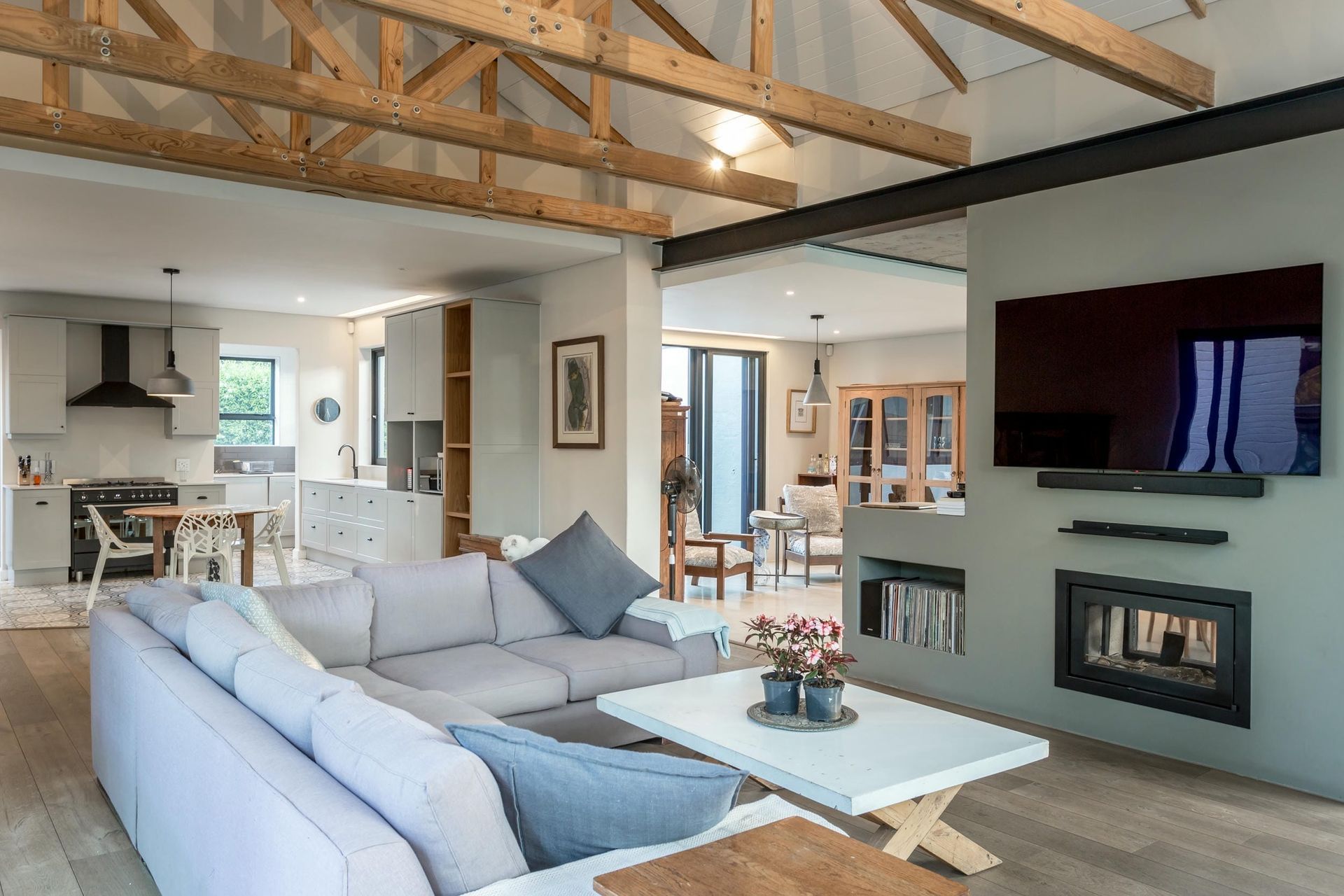 A living room with a couch , coffee table , television and fireplace.