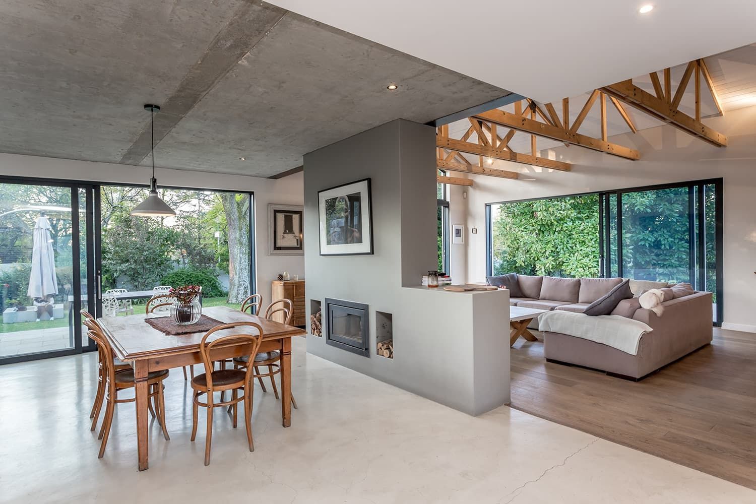 A living room with a dining table and chairs and a fireplace.