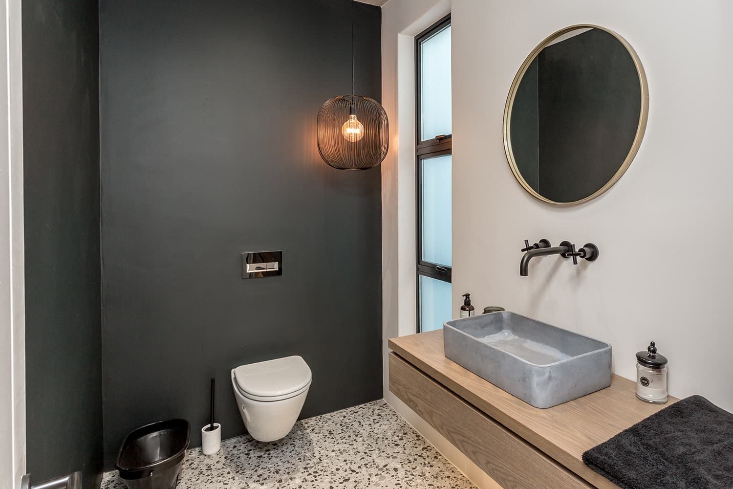 A bathroom with a toilet , sink and mirror.