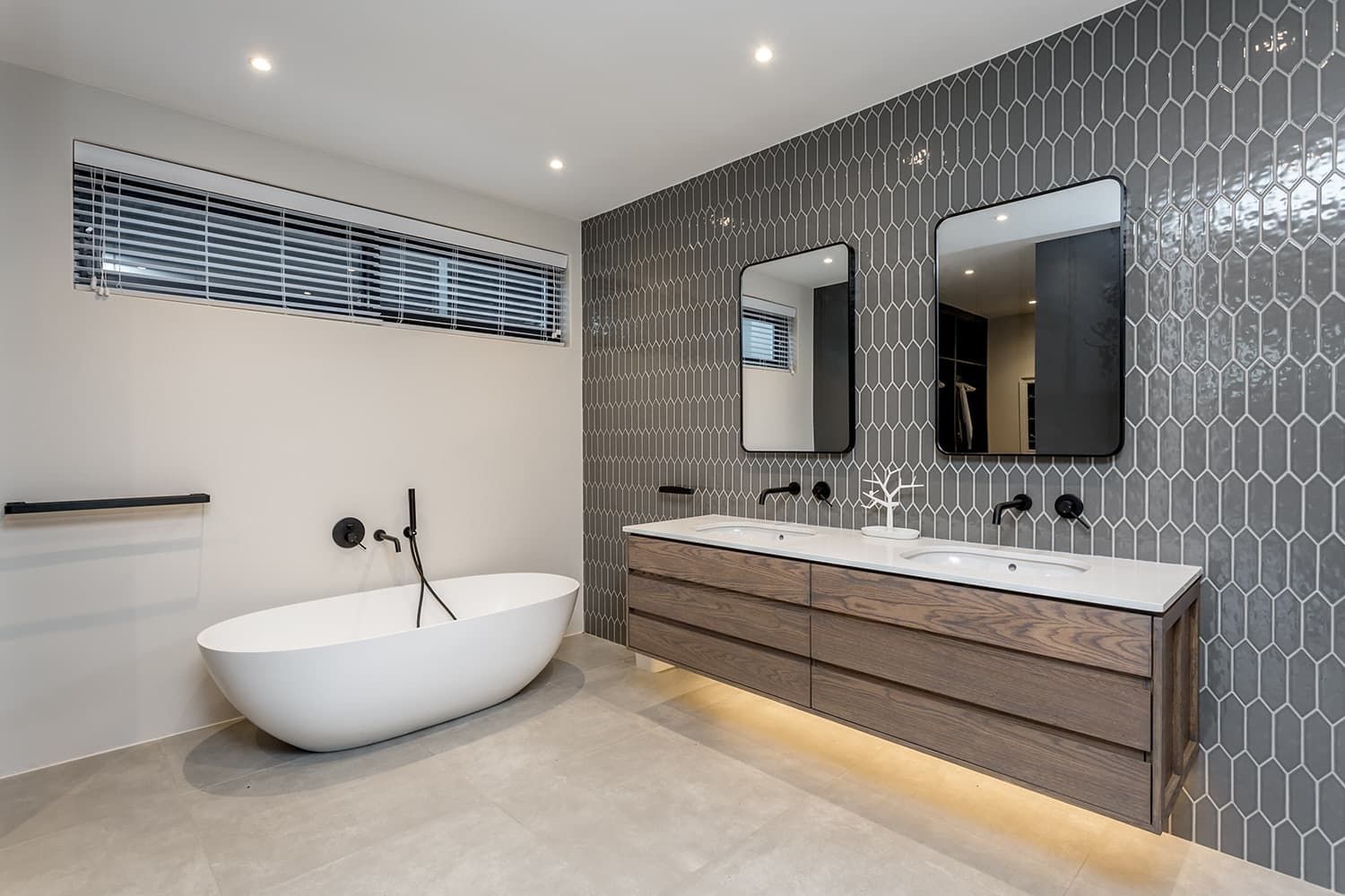 A bathroom with a bathtub , sinks and mirrors.