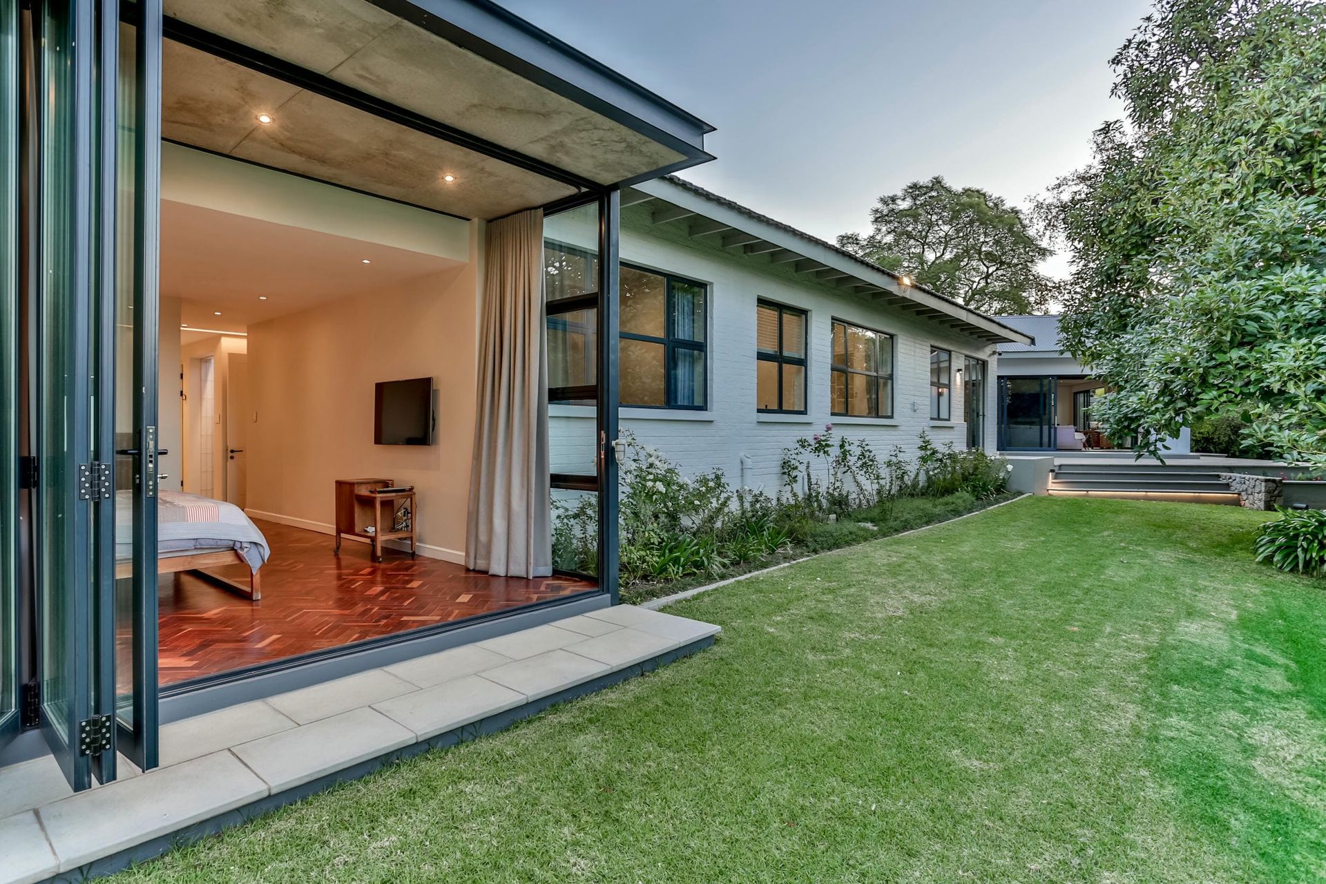 A white house with a large lawn in front of it.
