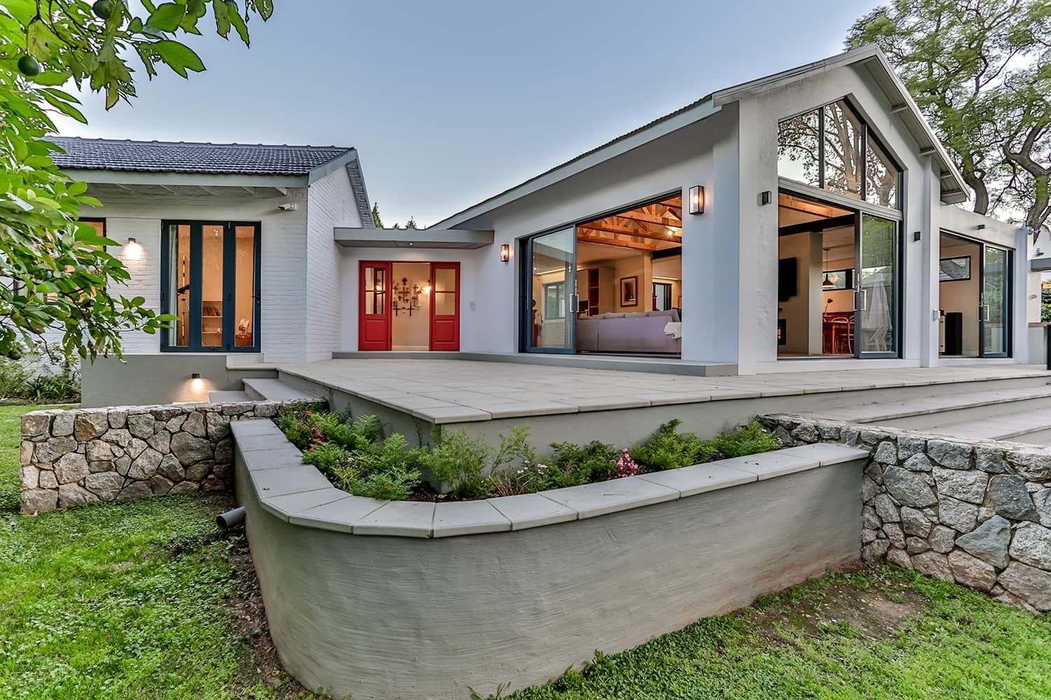 A large white house with a lot of windows and a red door