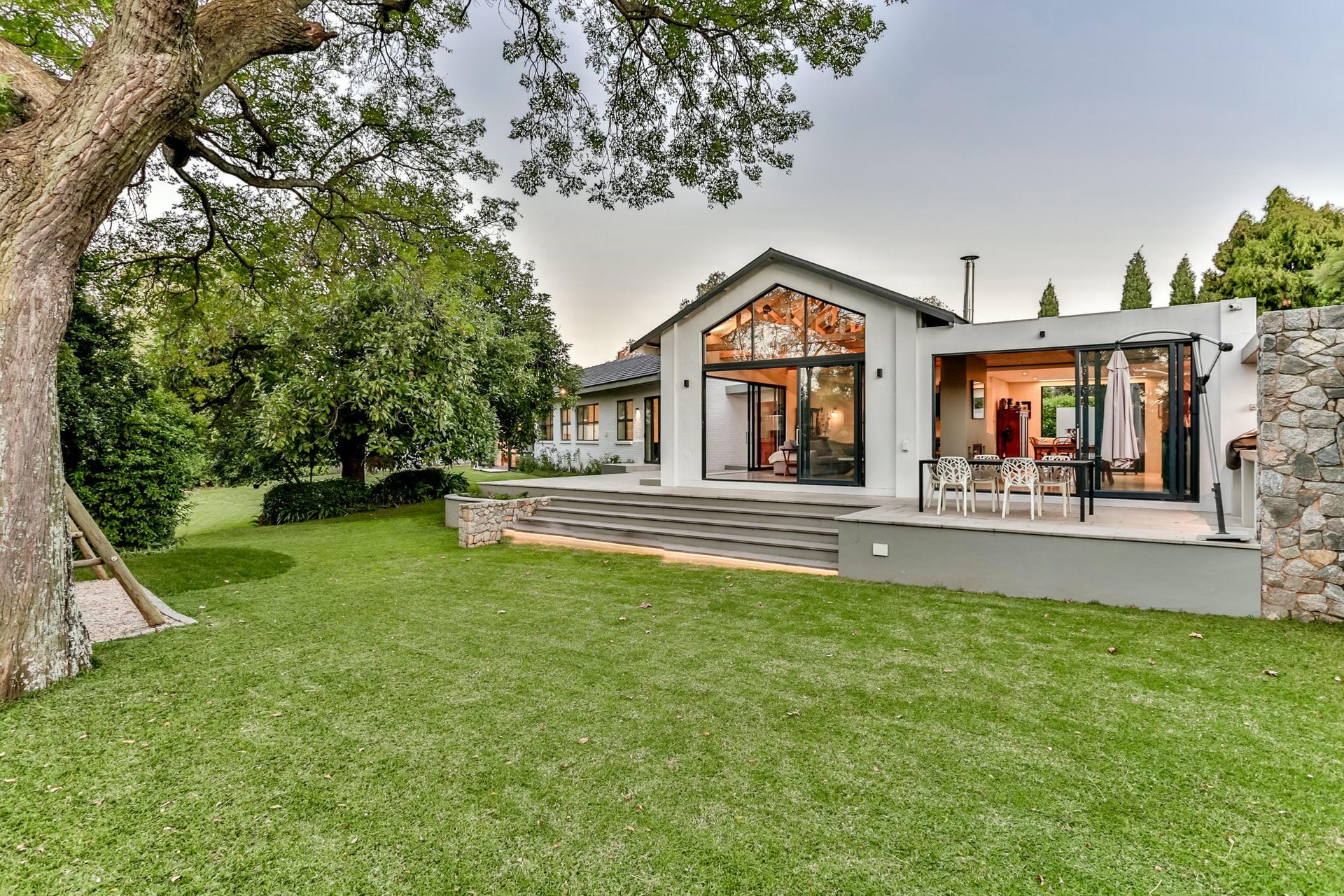 A large white house with a large lawn in front of it.