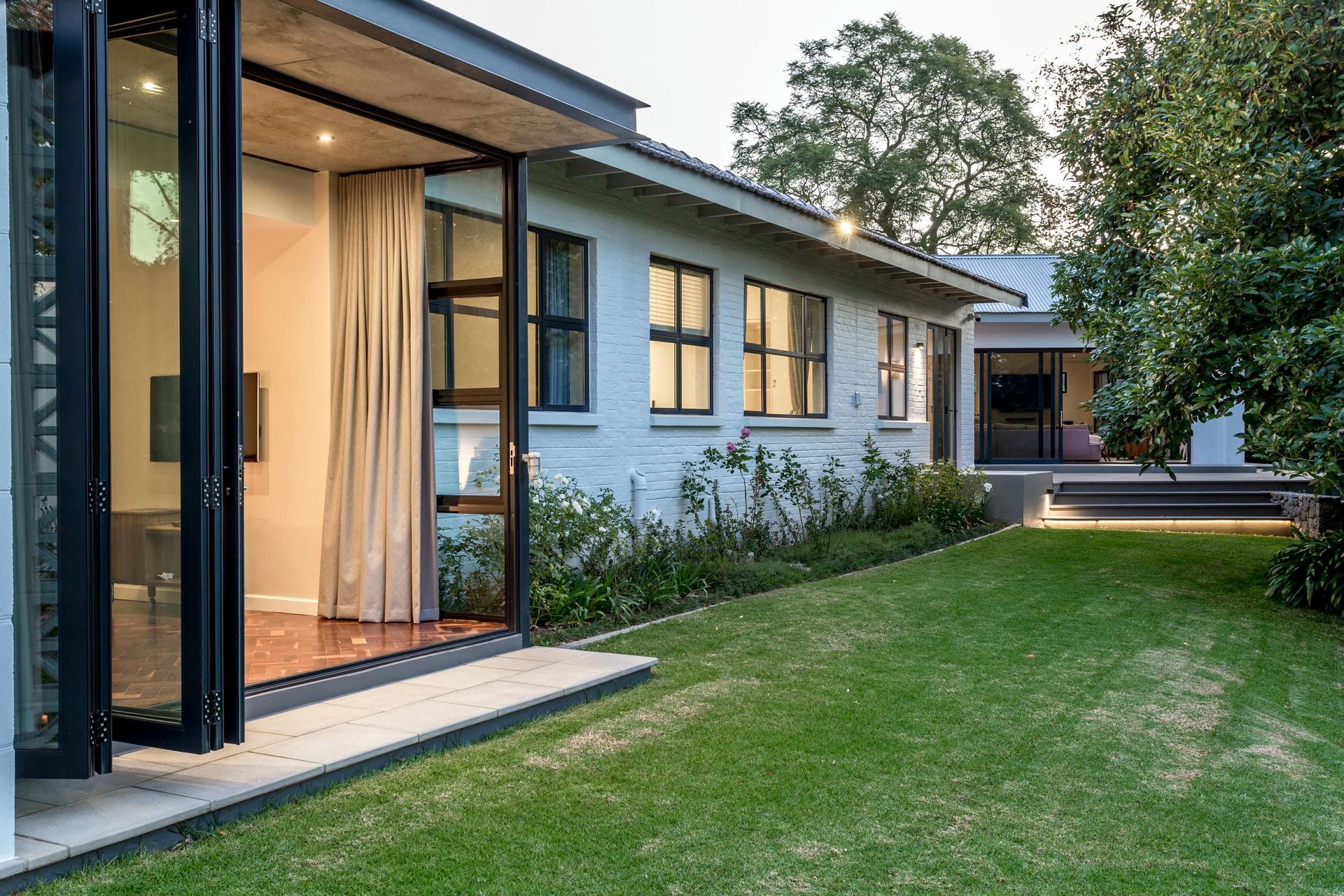 A white house with a large lawn in front of it.