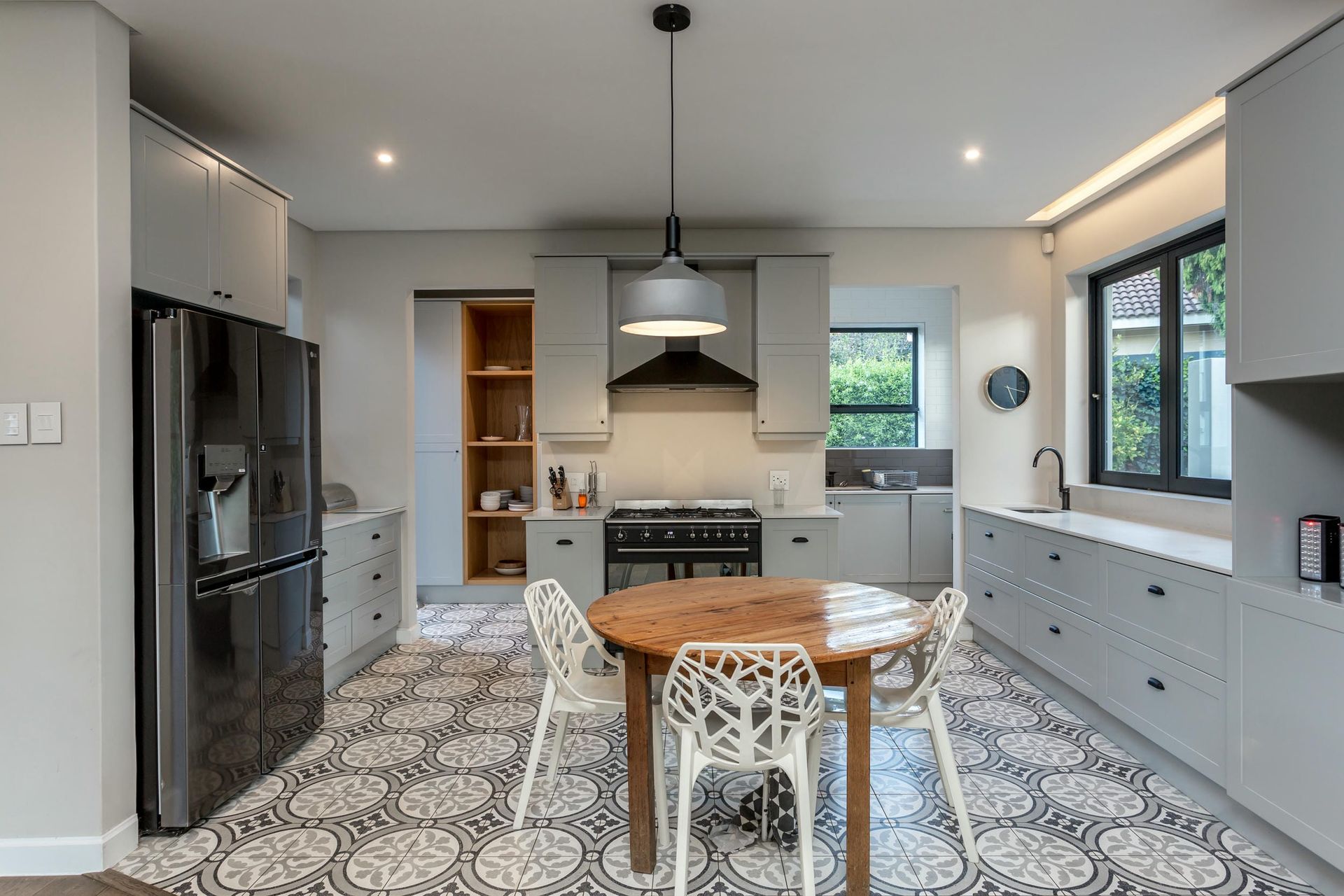 A kitchen with a table and chairs and a refrigerator.