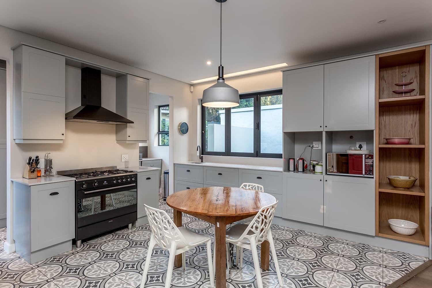 A kitchen with a table and chairs and a stove.
