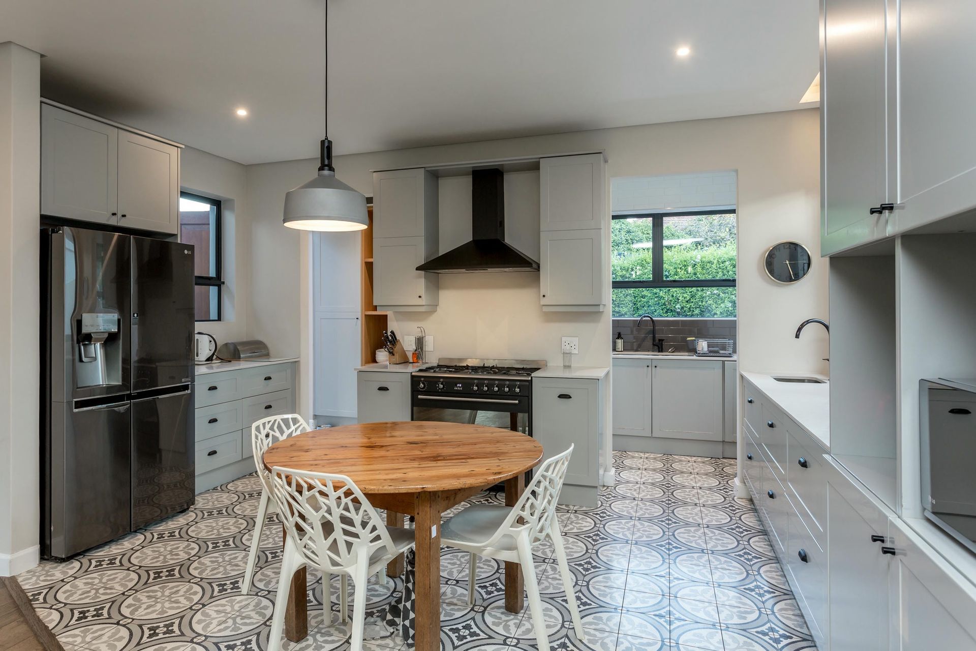 A kitchen with a table and chairs and a refrigerator.