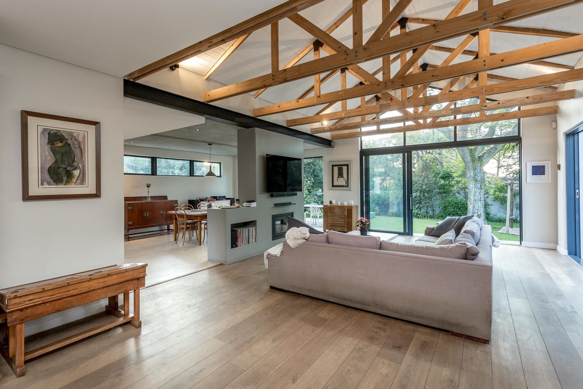 A living room with a couch , television , and wooden beams.