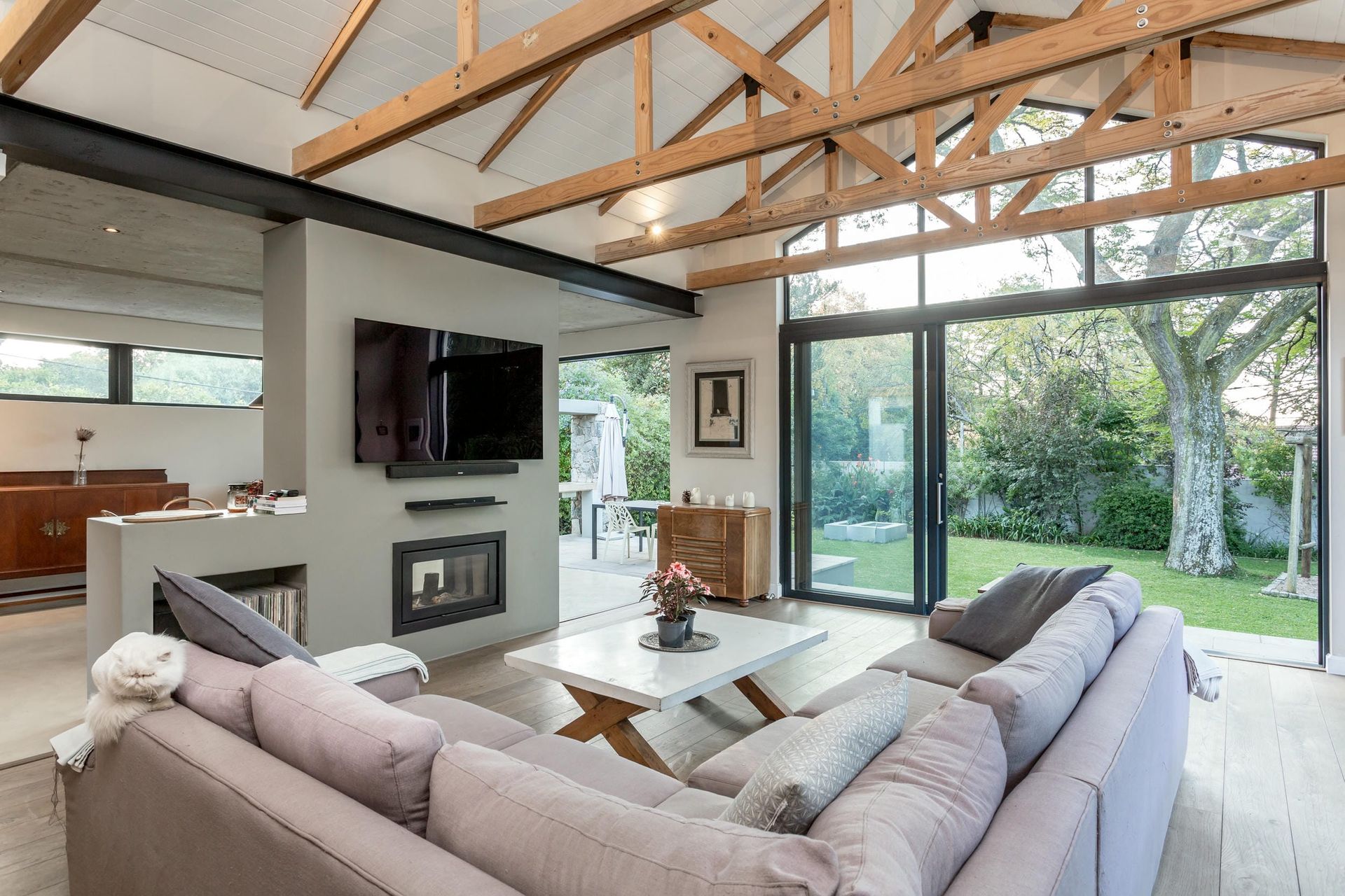 A living room with a couch , television , fireplace and sliding glass doors.
