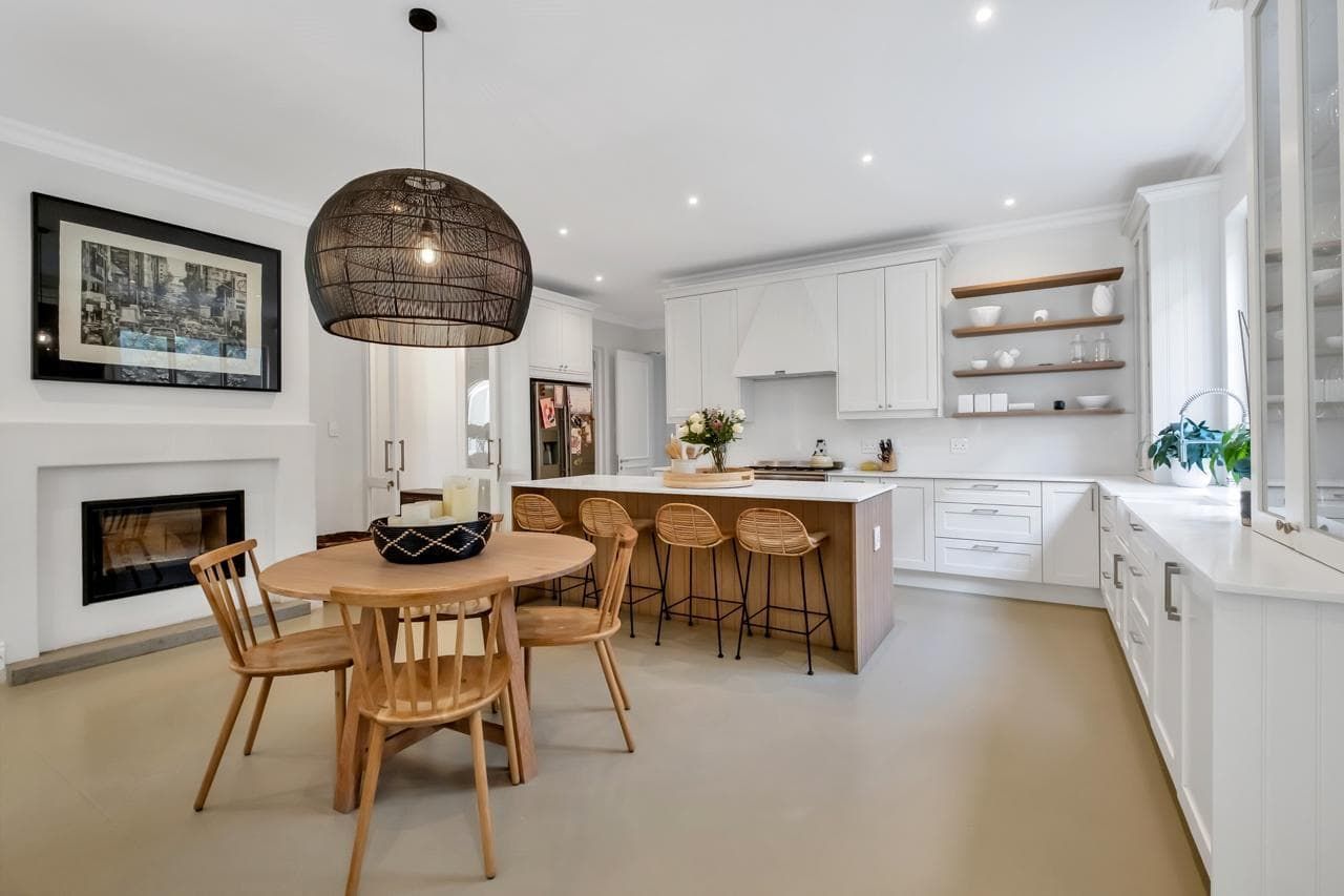 A hallway with a bench and stairs leading to a dining room