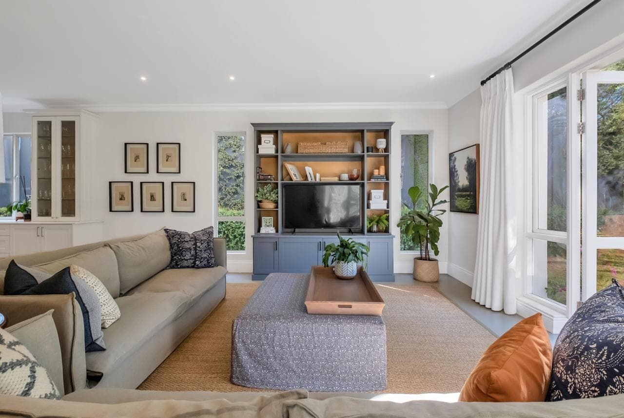 A living room with a couch , chair , coffee table , fireplace and television.