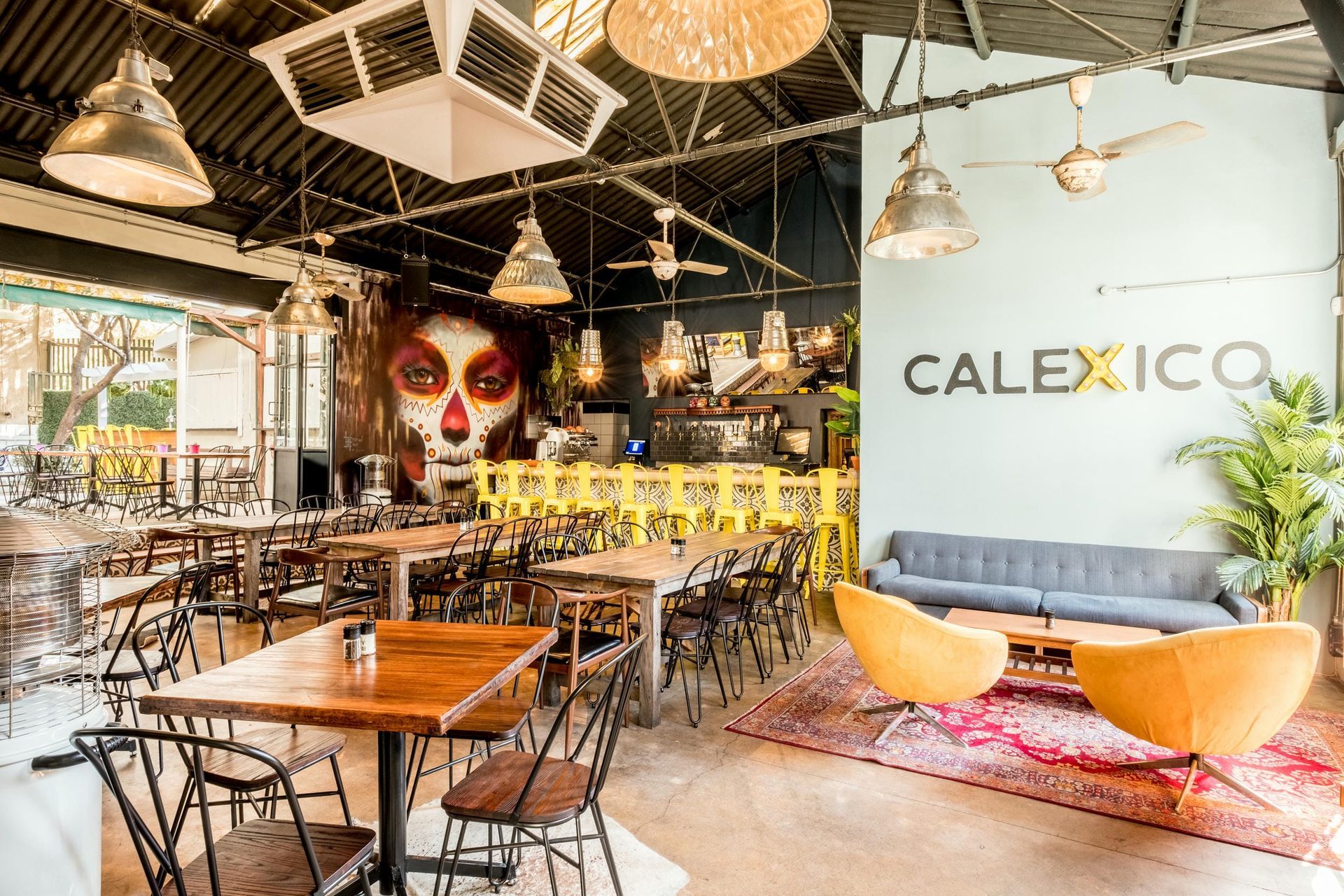 A restaurant with tables and chairs and a mural on the wall.