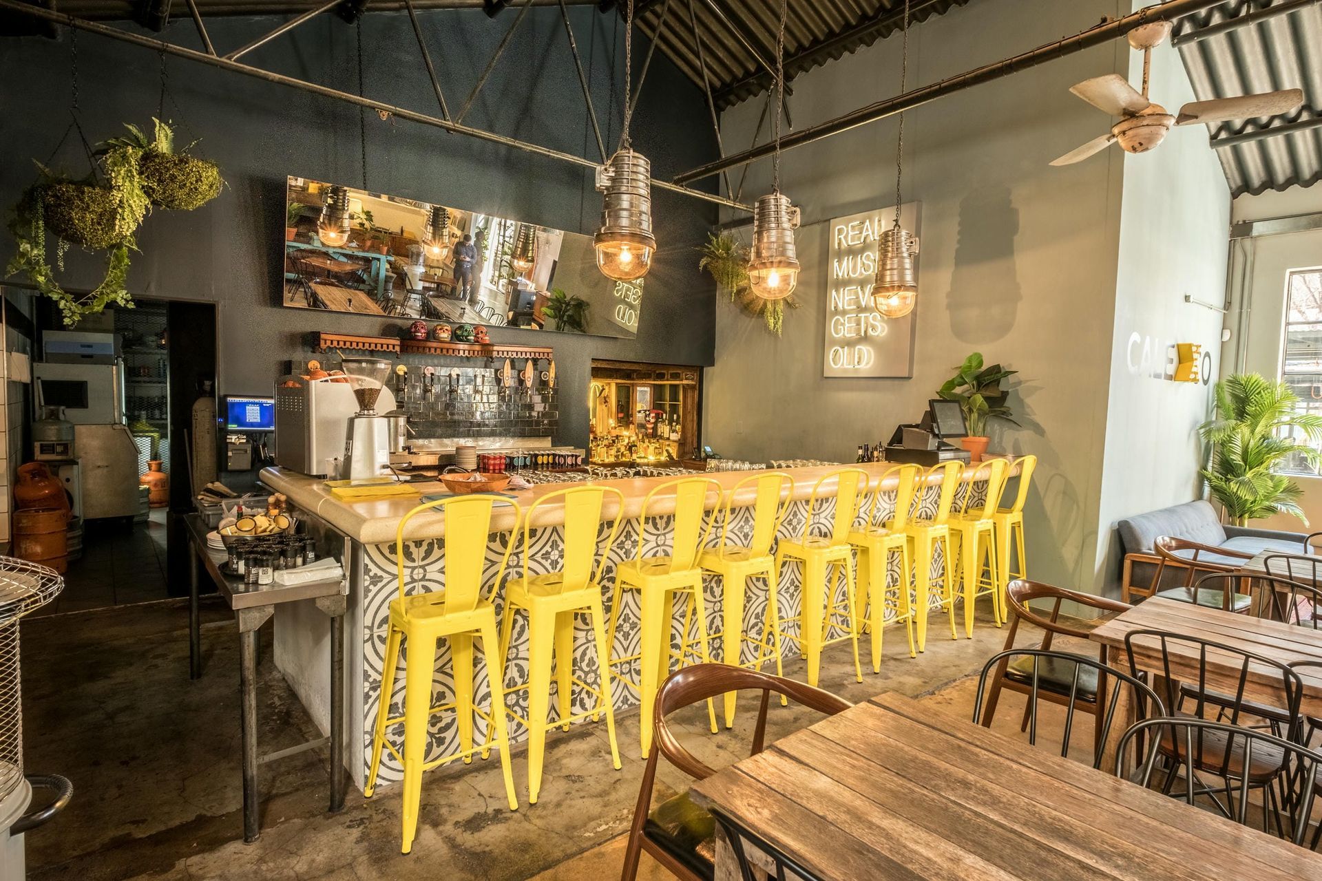 A restaurant with tables and chairs and a bar.