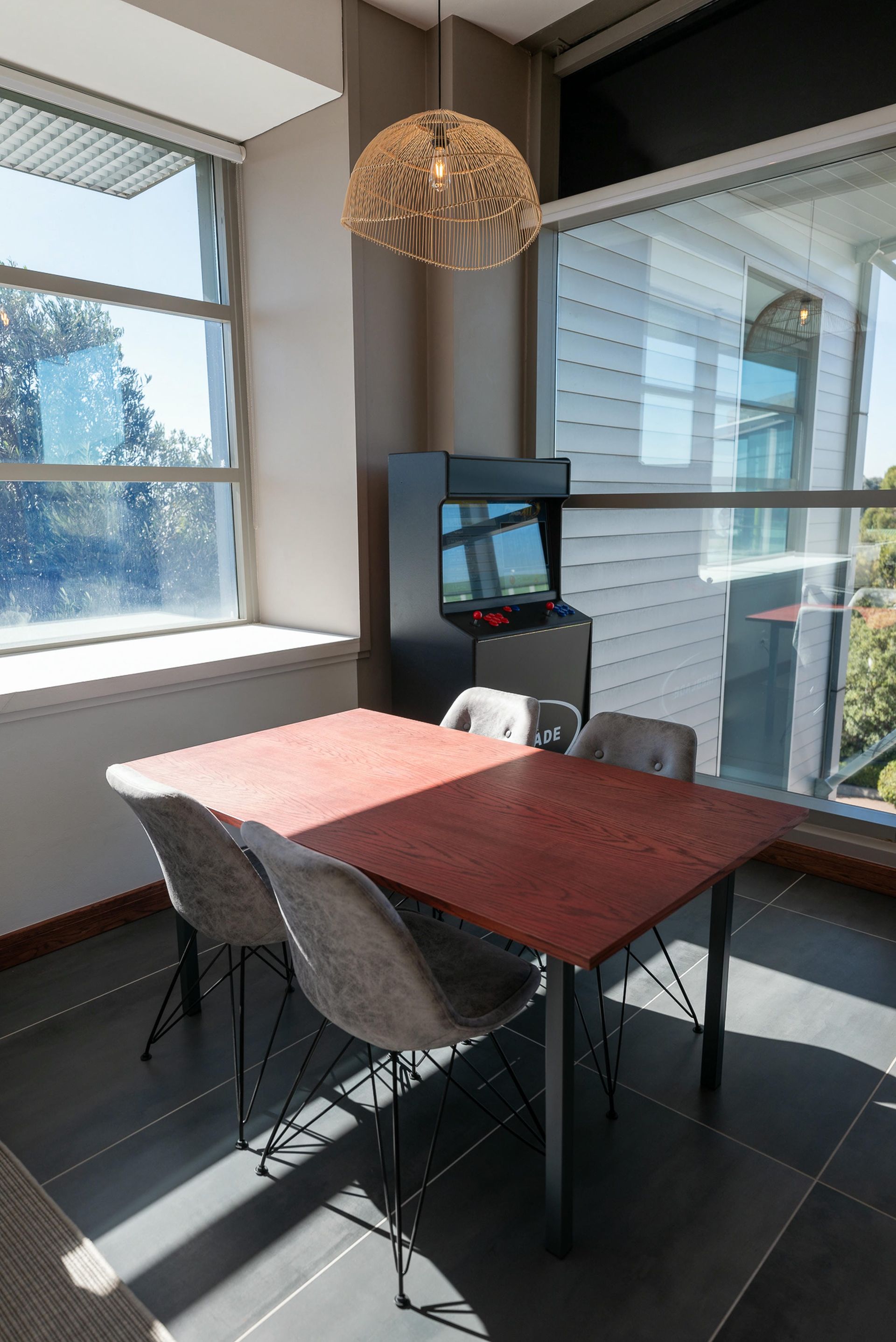 A room with a table and chairs in front of a window.
