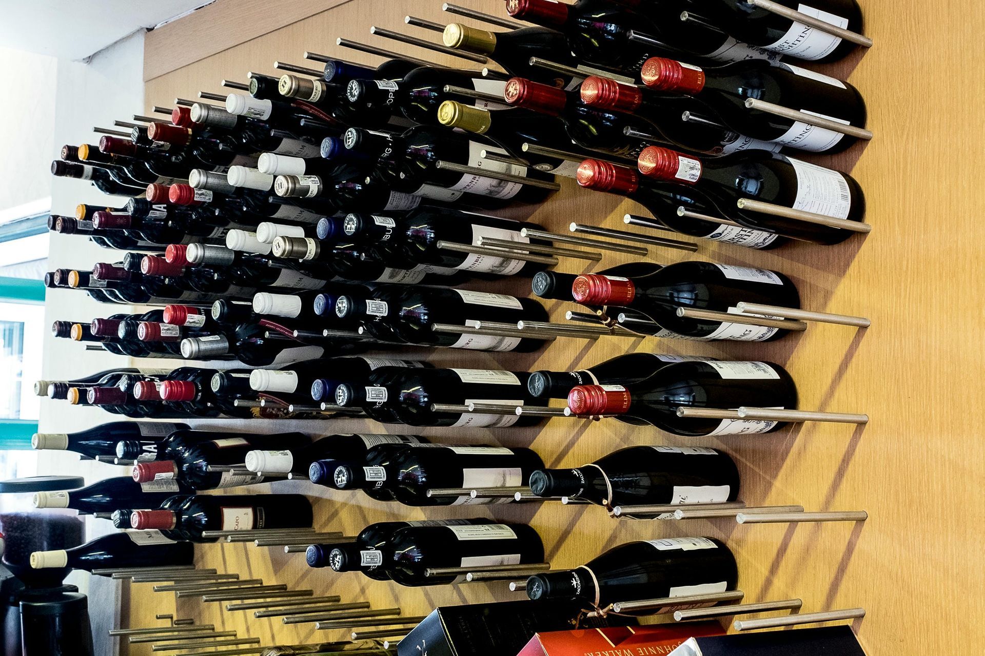 A bunch of wine bottles are lined up on a rack