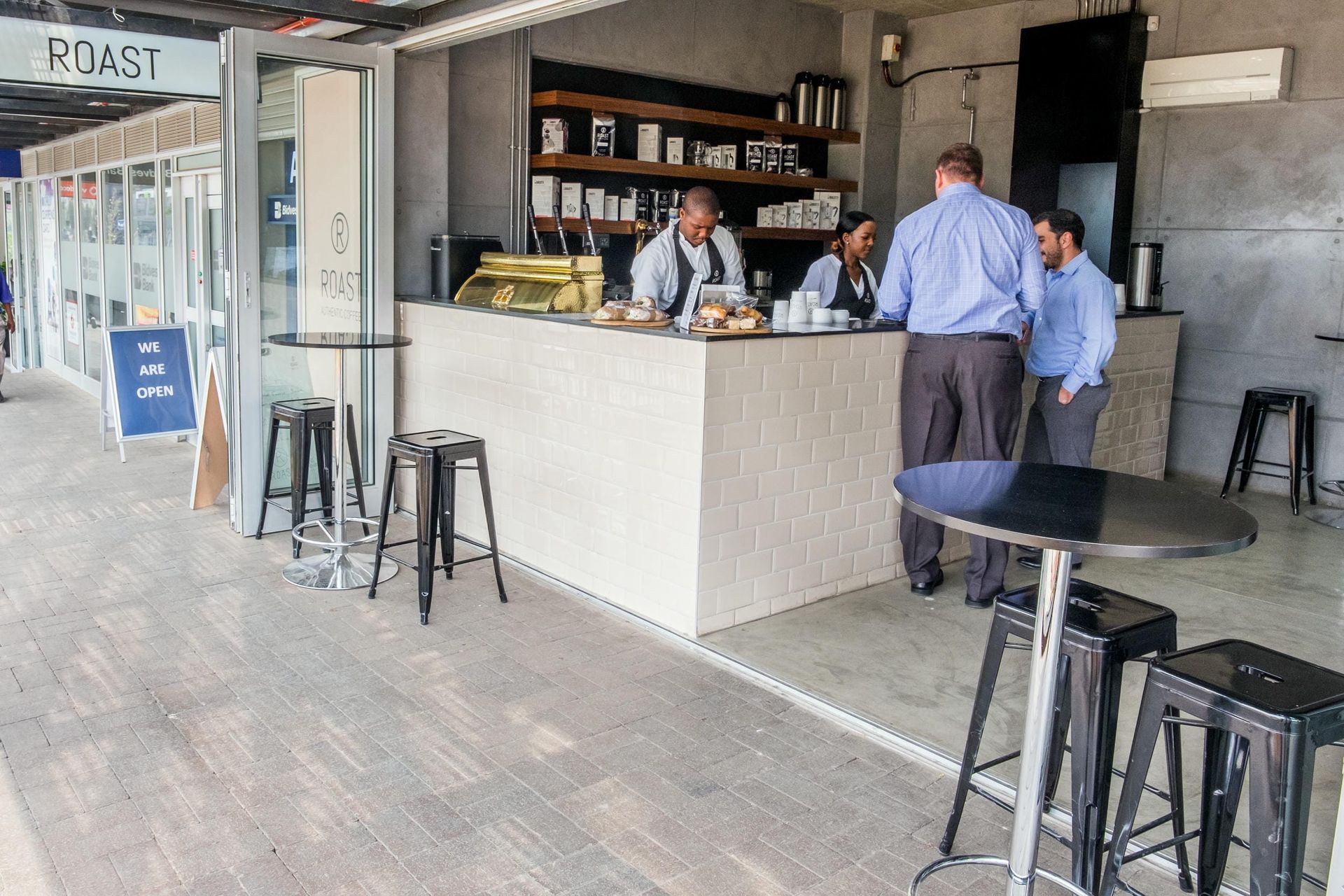 A group of people are standing around a counter in a restaurant.