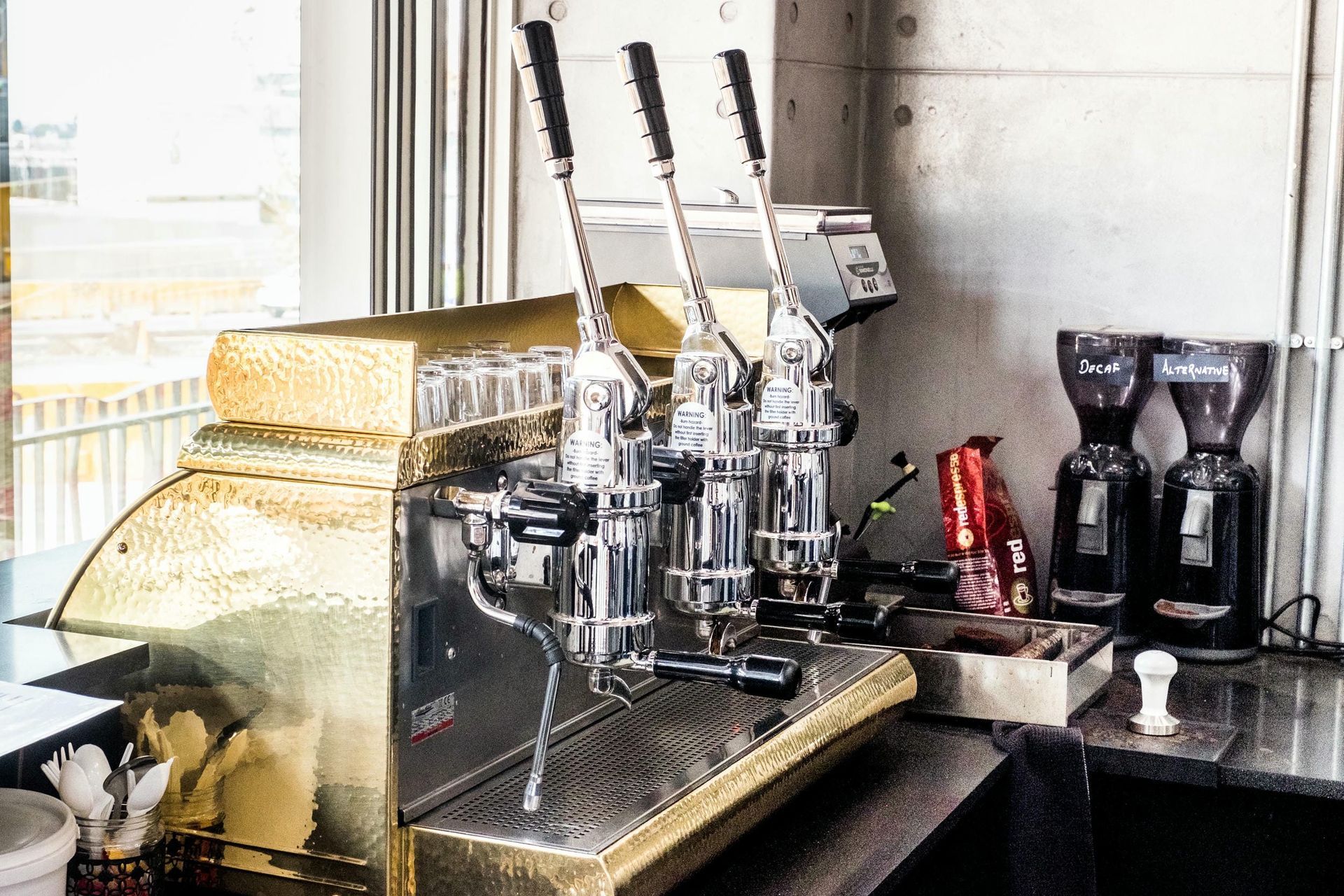 A coffee machine is sitting on a counter next to a window.