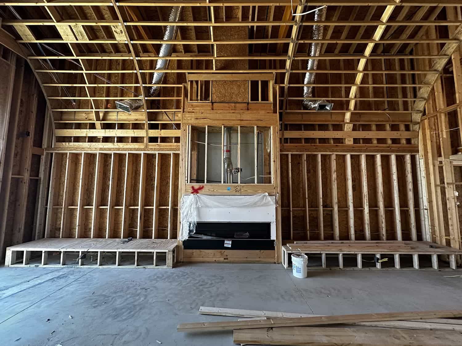 A room in a house under construction with a fireplace.