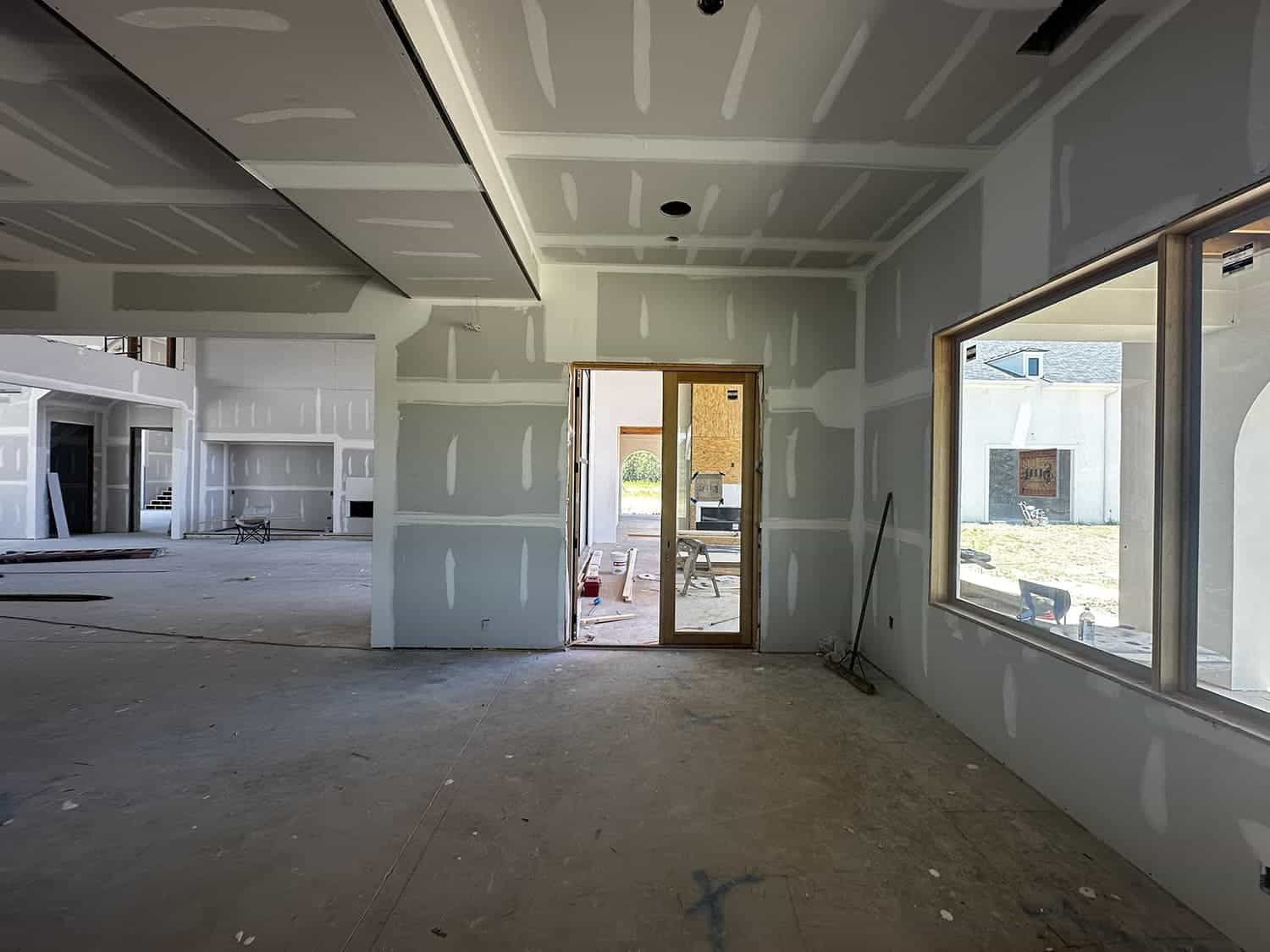 An empty room with drywall on the walls and windows