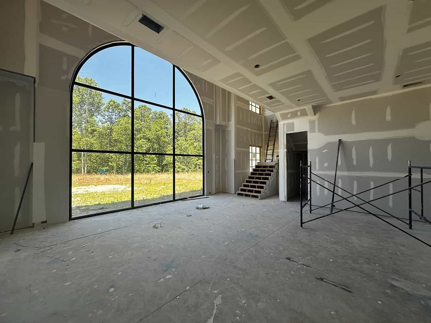 An empty room with a large window and stairs.